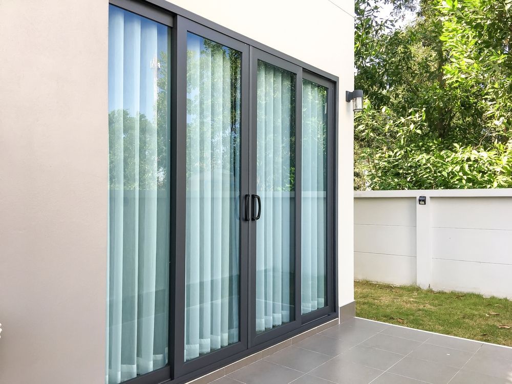 Sliding Glass Doors With Black Frames and Sheer Curtains — Working Windows in Ballina, NSW