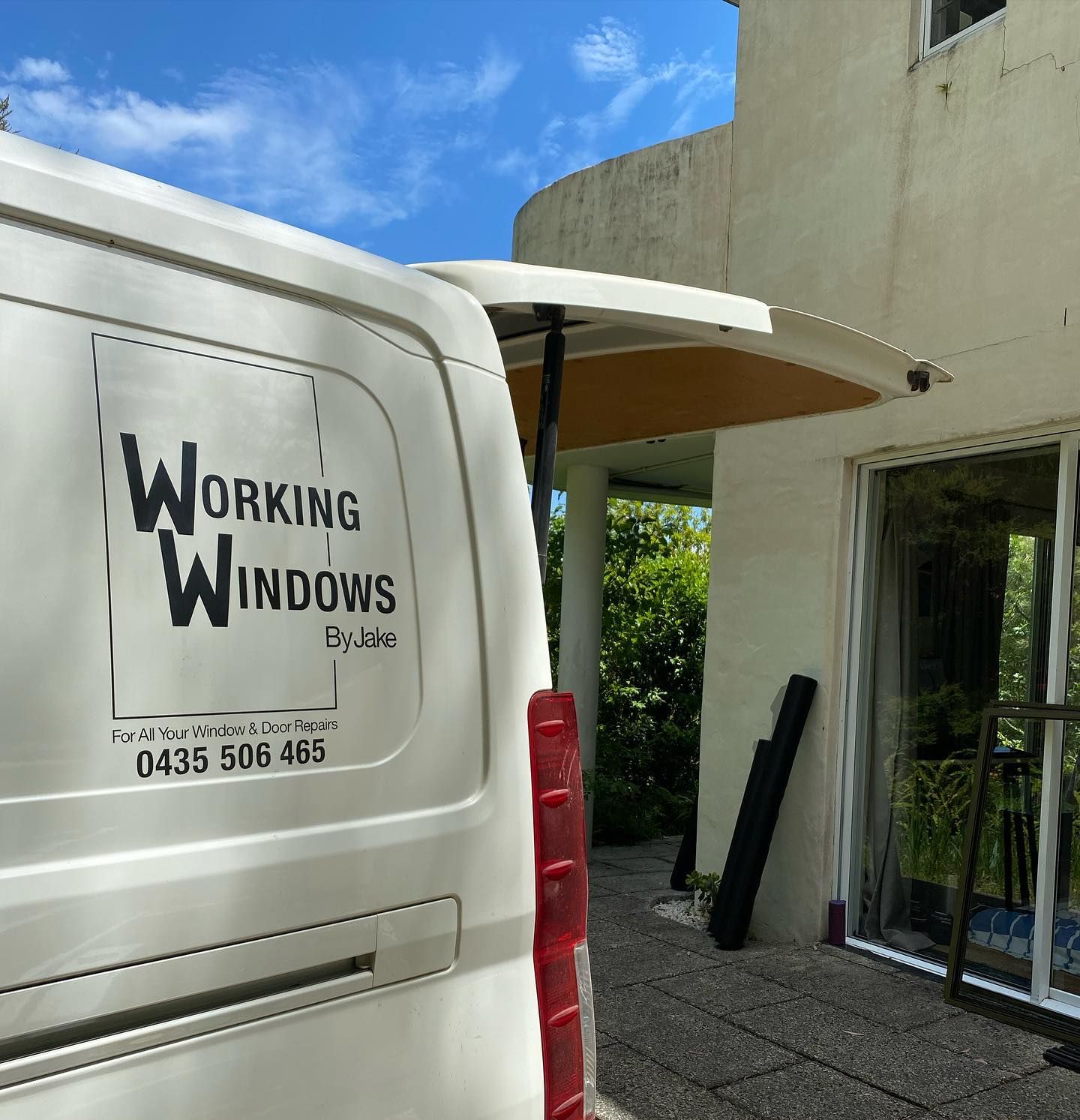White Van With Working Windows Logo Parked Outside a Building, Door Open — Working Windows in Byron Bay, NSW