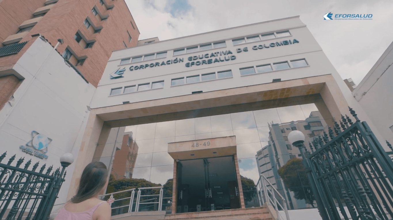 Una mujer se encuentra frente a un edificio que dice Colombia.