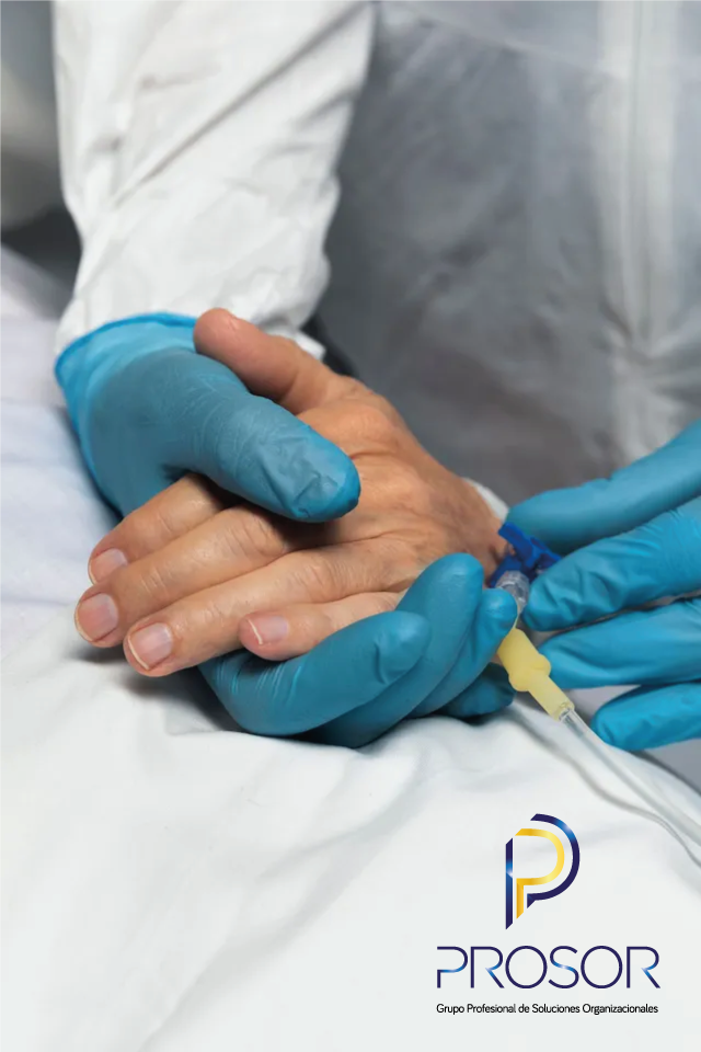 Un médico sostiene la mano de un paciente en una cama de hospital.