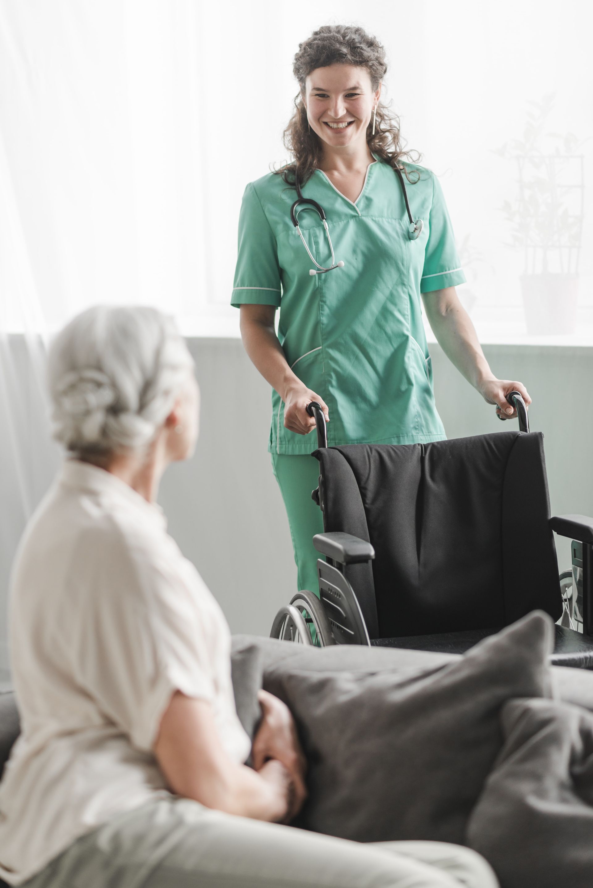 Una mujer sostiene la mano de un paciente en una cama de hospital.