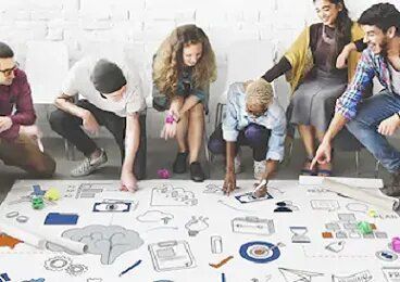 Un grupo de personas está dibujando en una pizarra blanca.