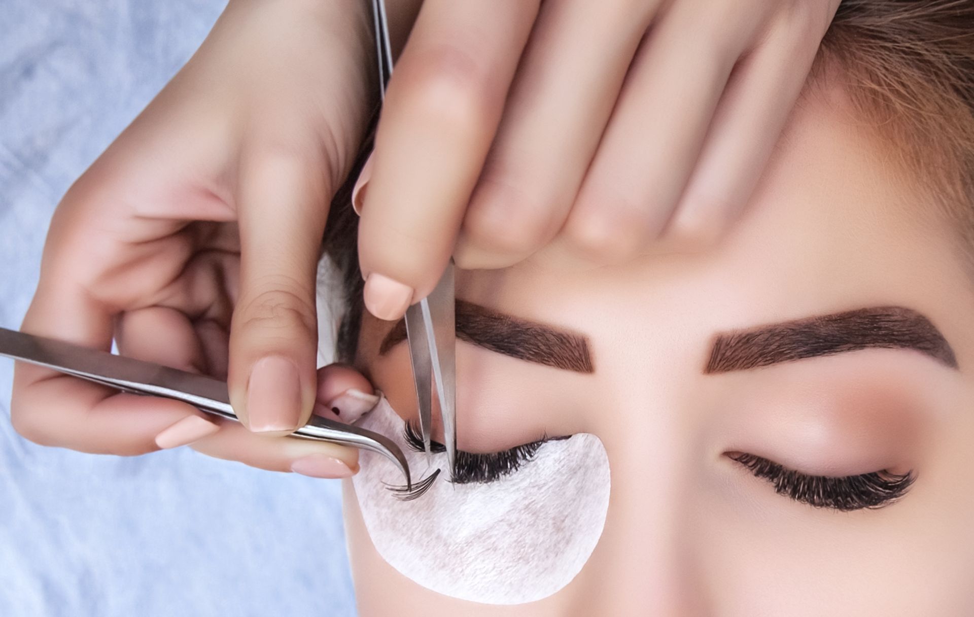 Una mujer se está haciendo las pestañas en un salón de belleza.