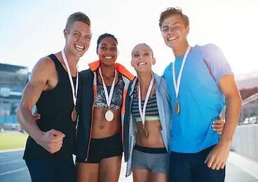 Un grupo de jóvenes posa para una foto con medallas alrededor de sus cuellos.