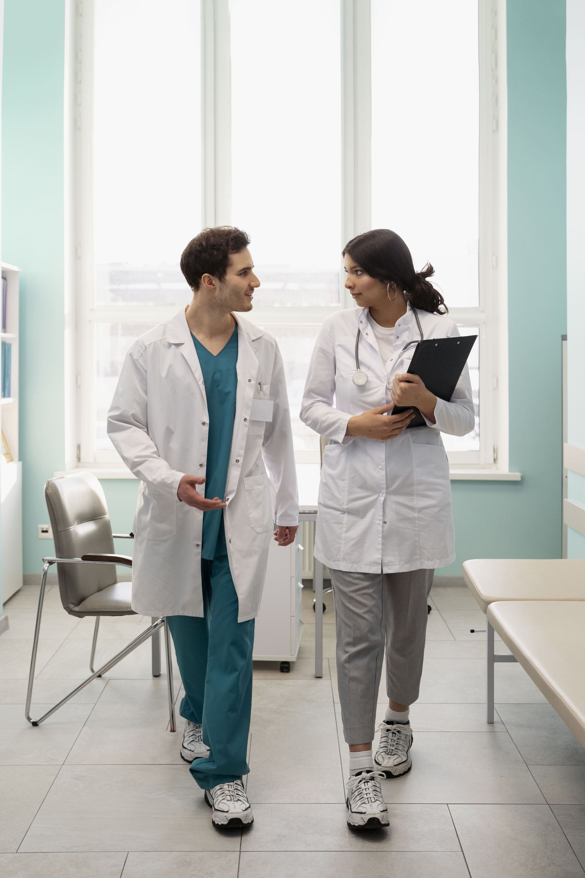 Un médico sostiene la mano de un paciente en una cama de hospital.