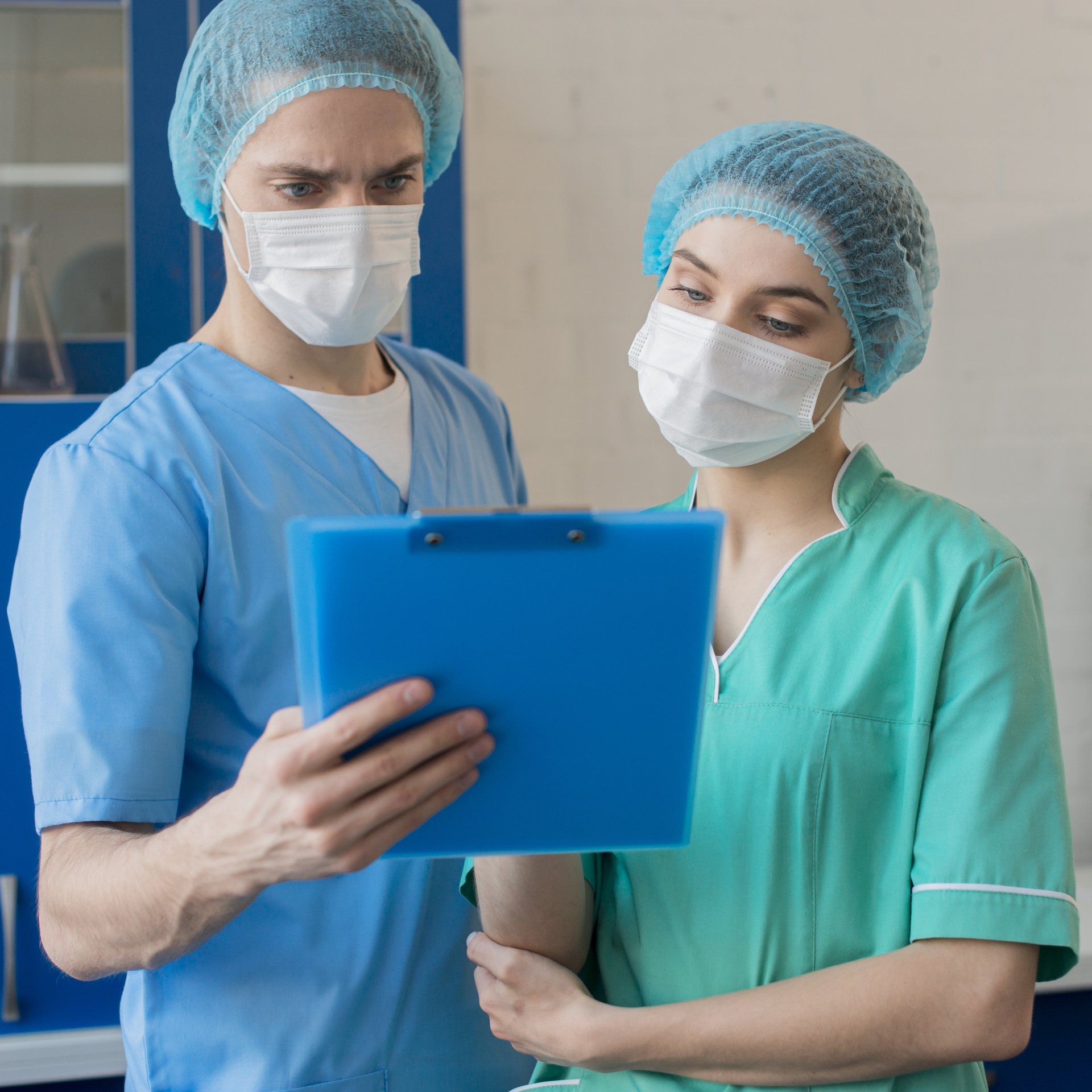 Un hombre y una mujer con máscaras miran un portapapeles.