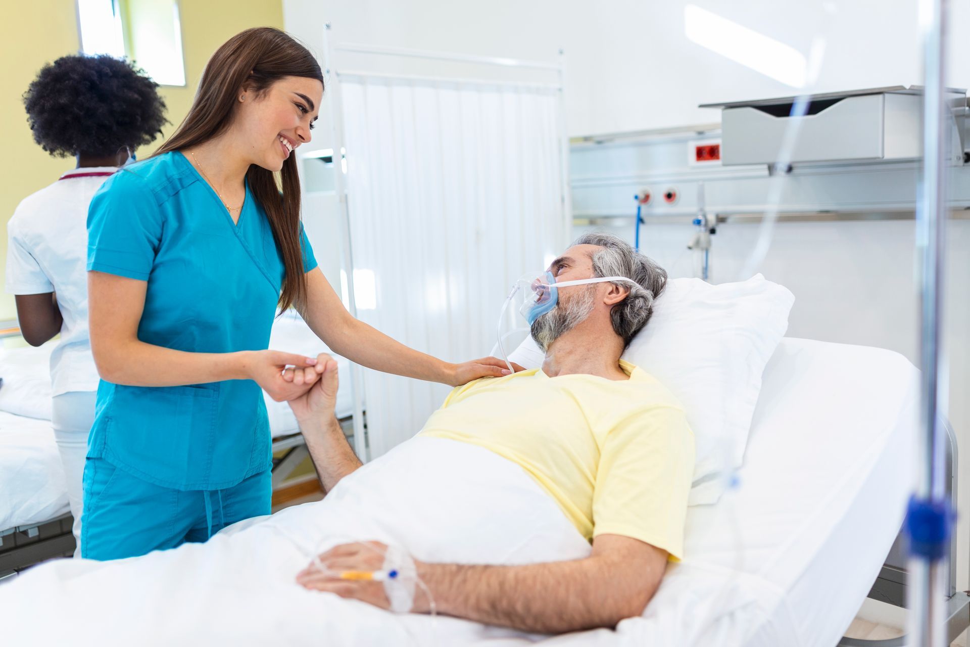 Un médico sostiene la mano de un paciente en una cama de hospital.