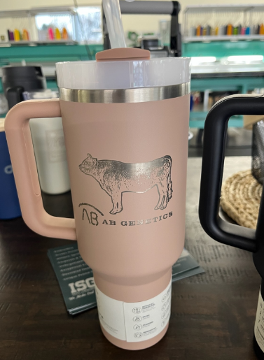 Pink insulated mug with a handle and a cow graphic.