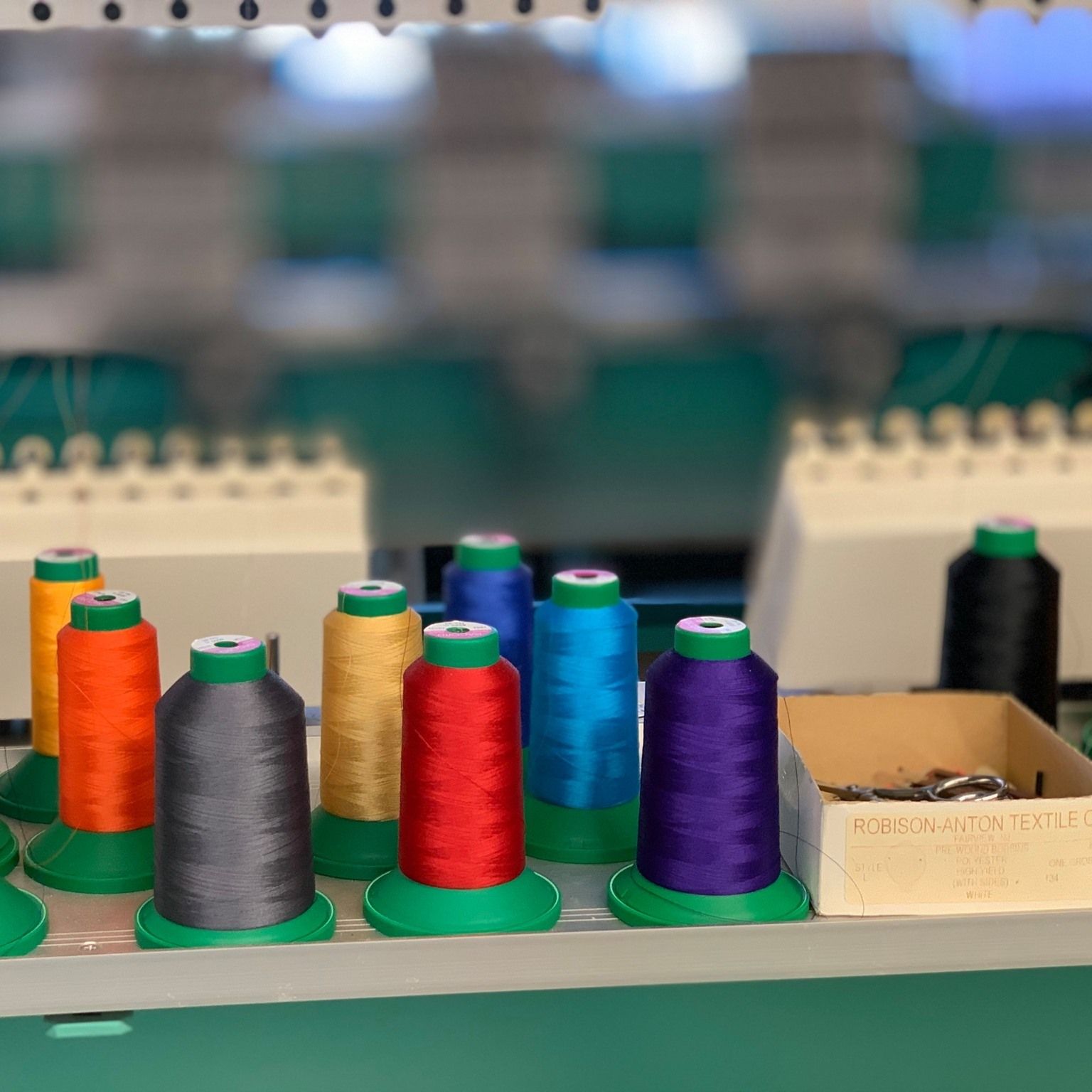 Colorful spools of thread, arranged on a machine, ready for embroidery.
