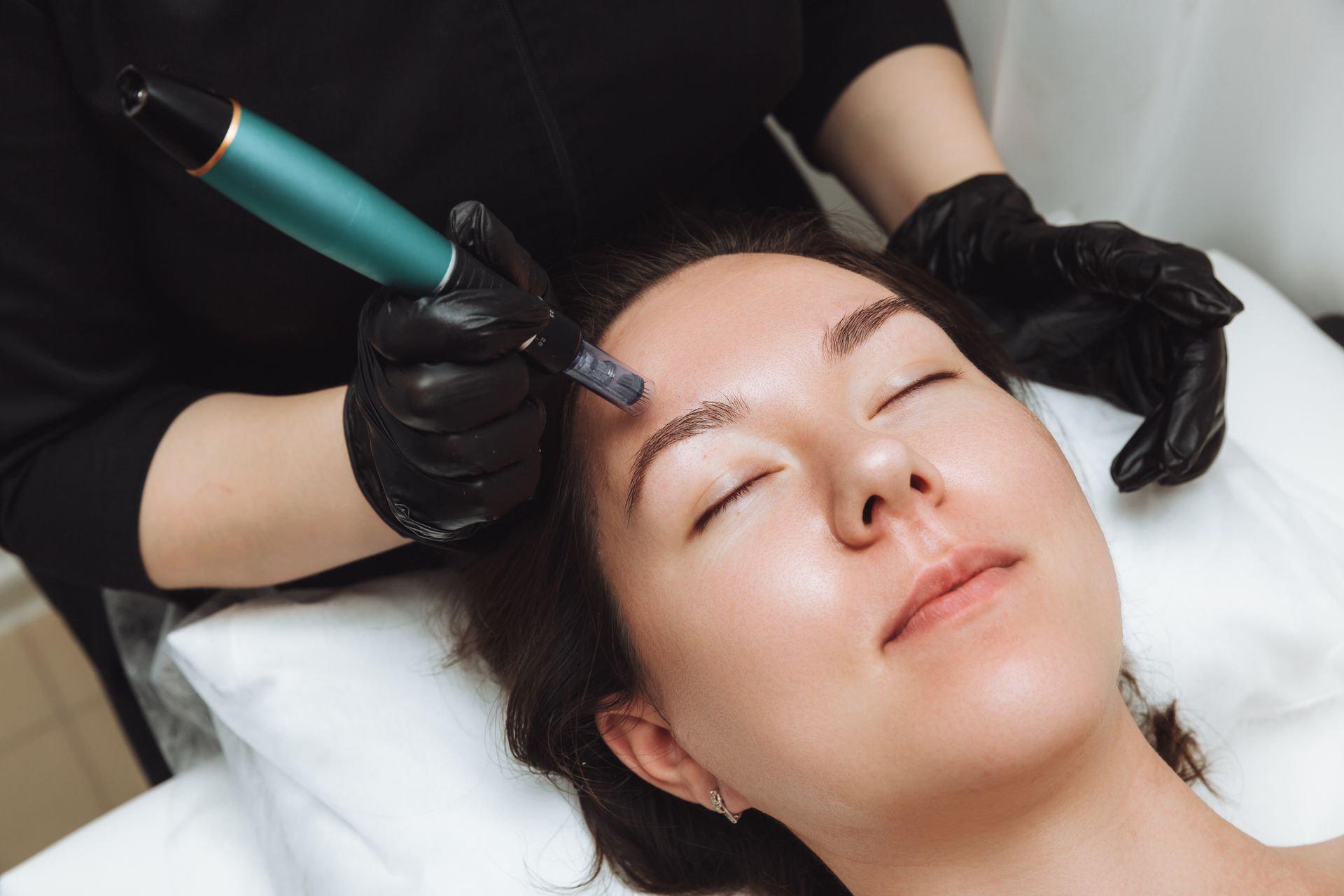 A woman is getting a microdermabrasion treatment on her face.