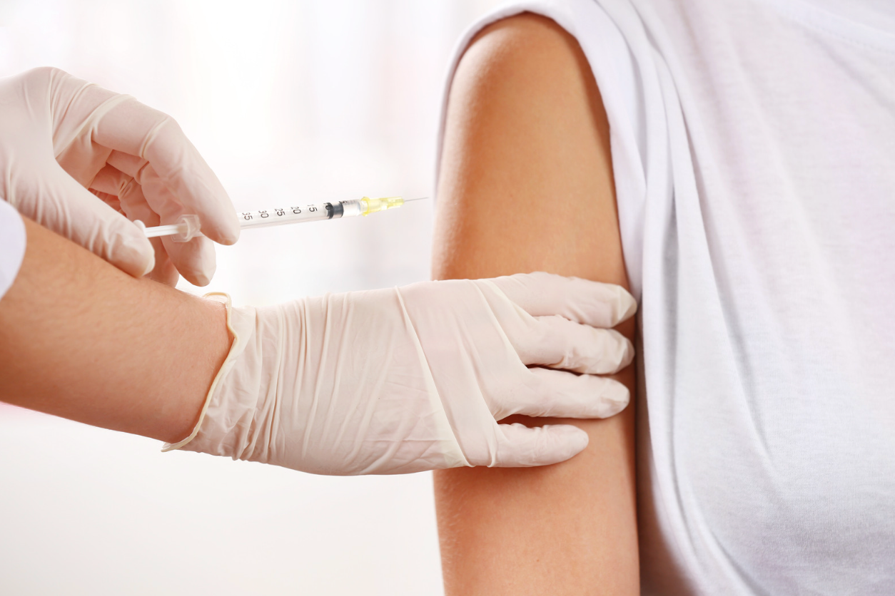 A woman is getting an injection in her stomach.