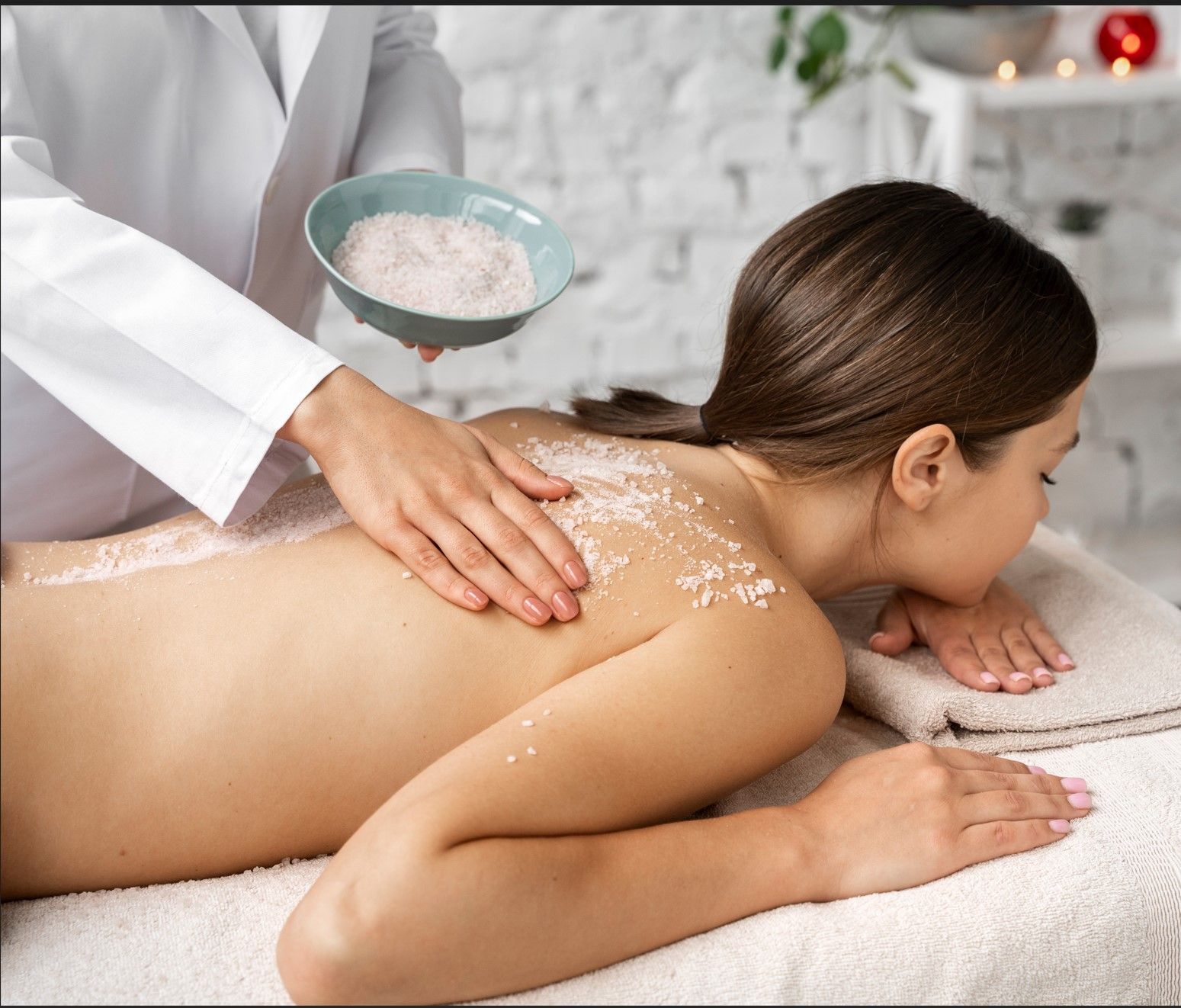 A woman is getting a body scrub at a spa.