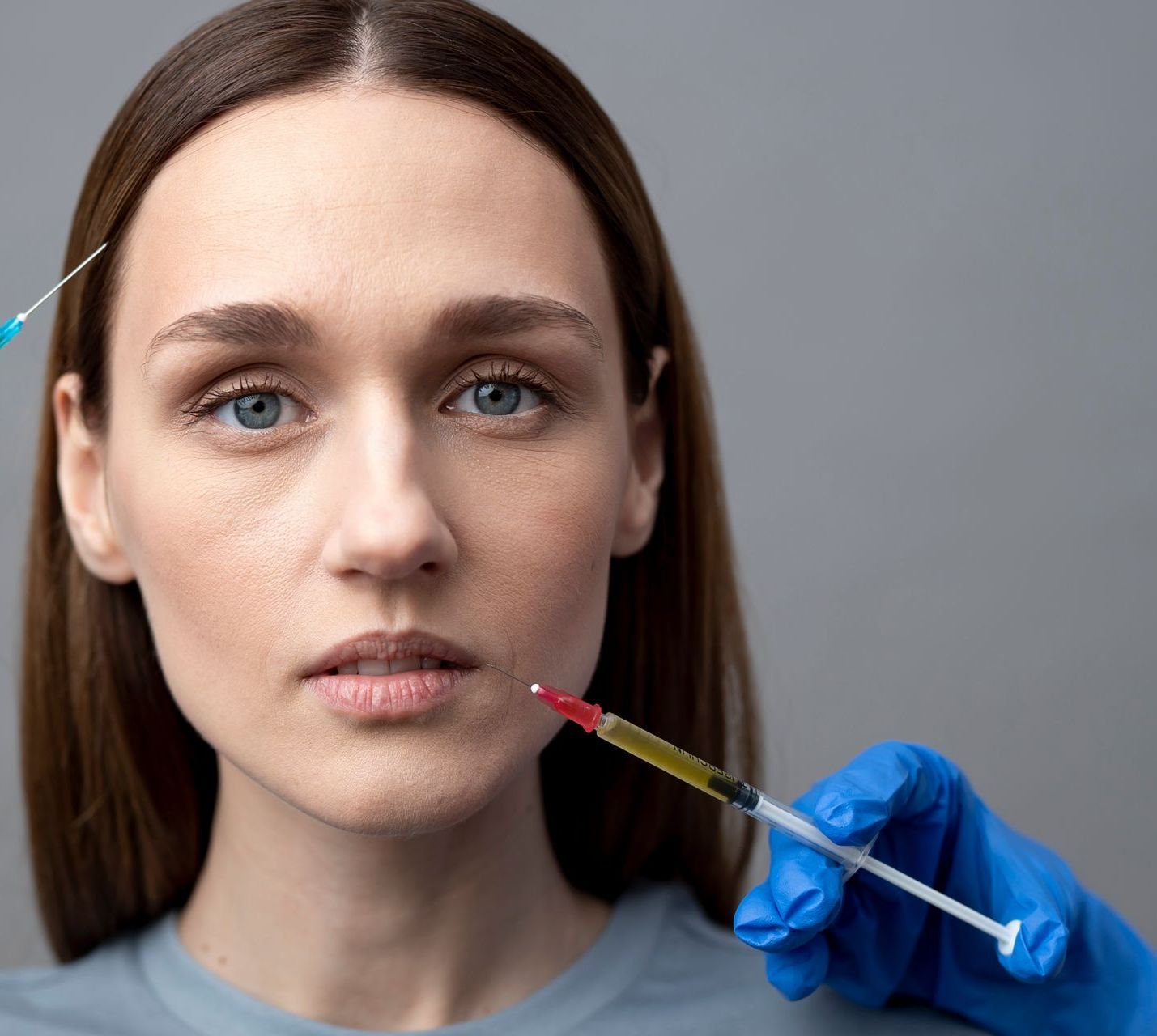 A woman is getting a botox injection in her face.