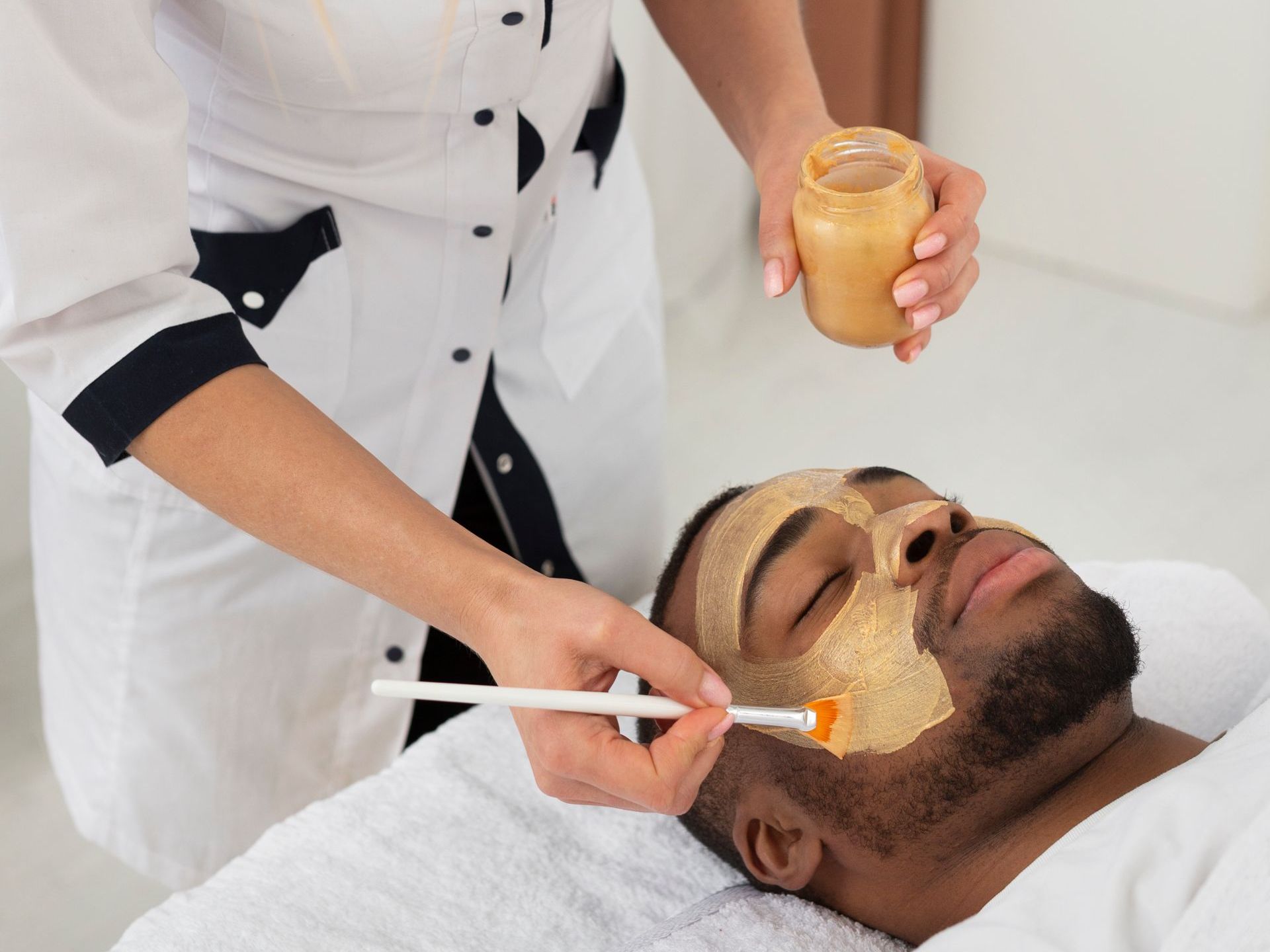 A man is getting a facial treatment at a spa.