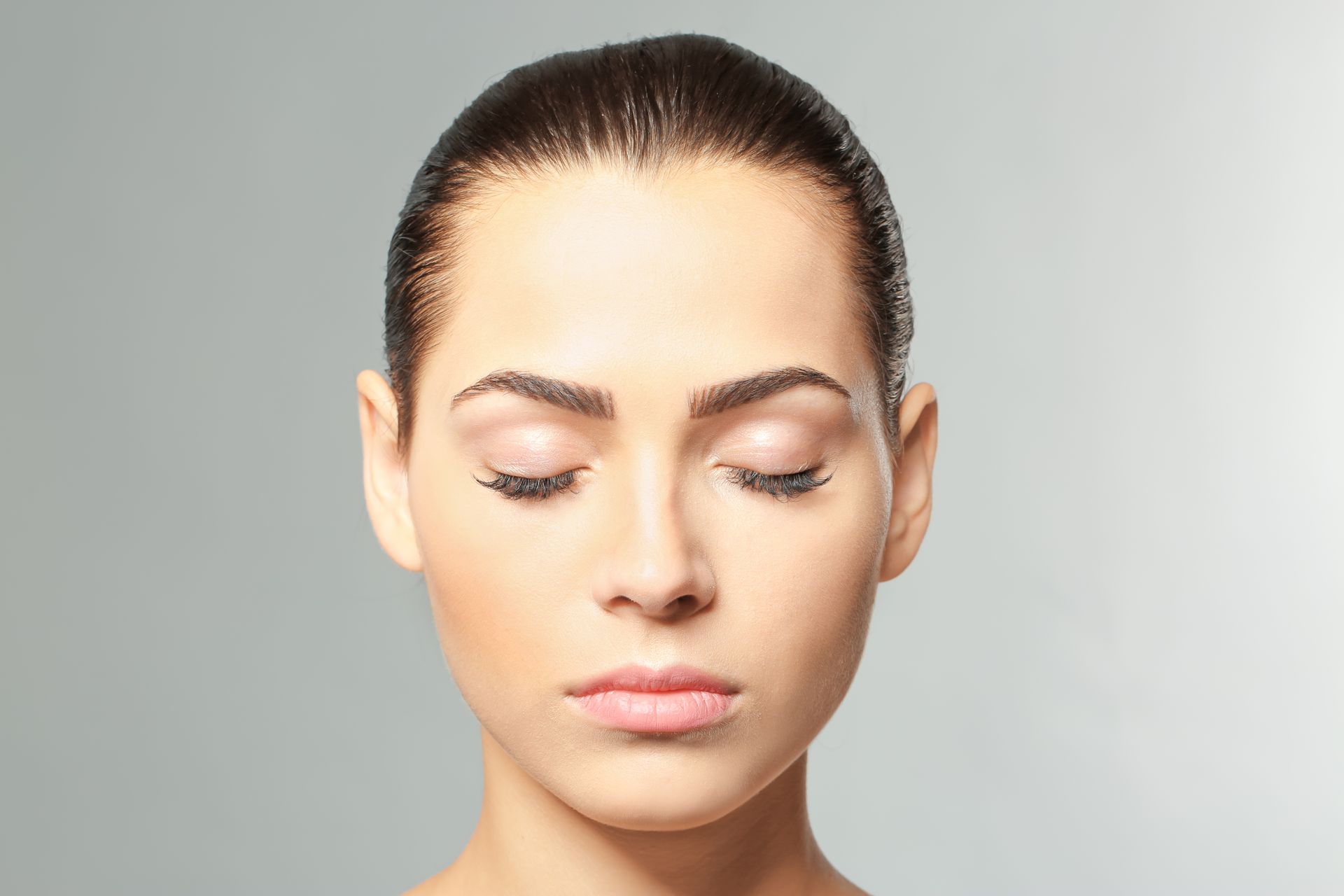 A close up of a woman 's face with her eyes closed.