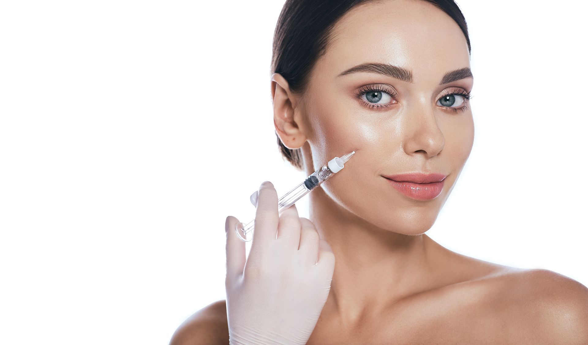 A woman is touching her face with her hand and looking at the camera.
