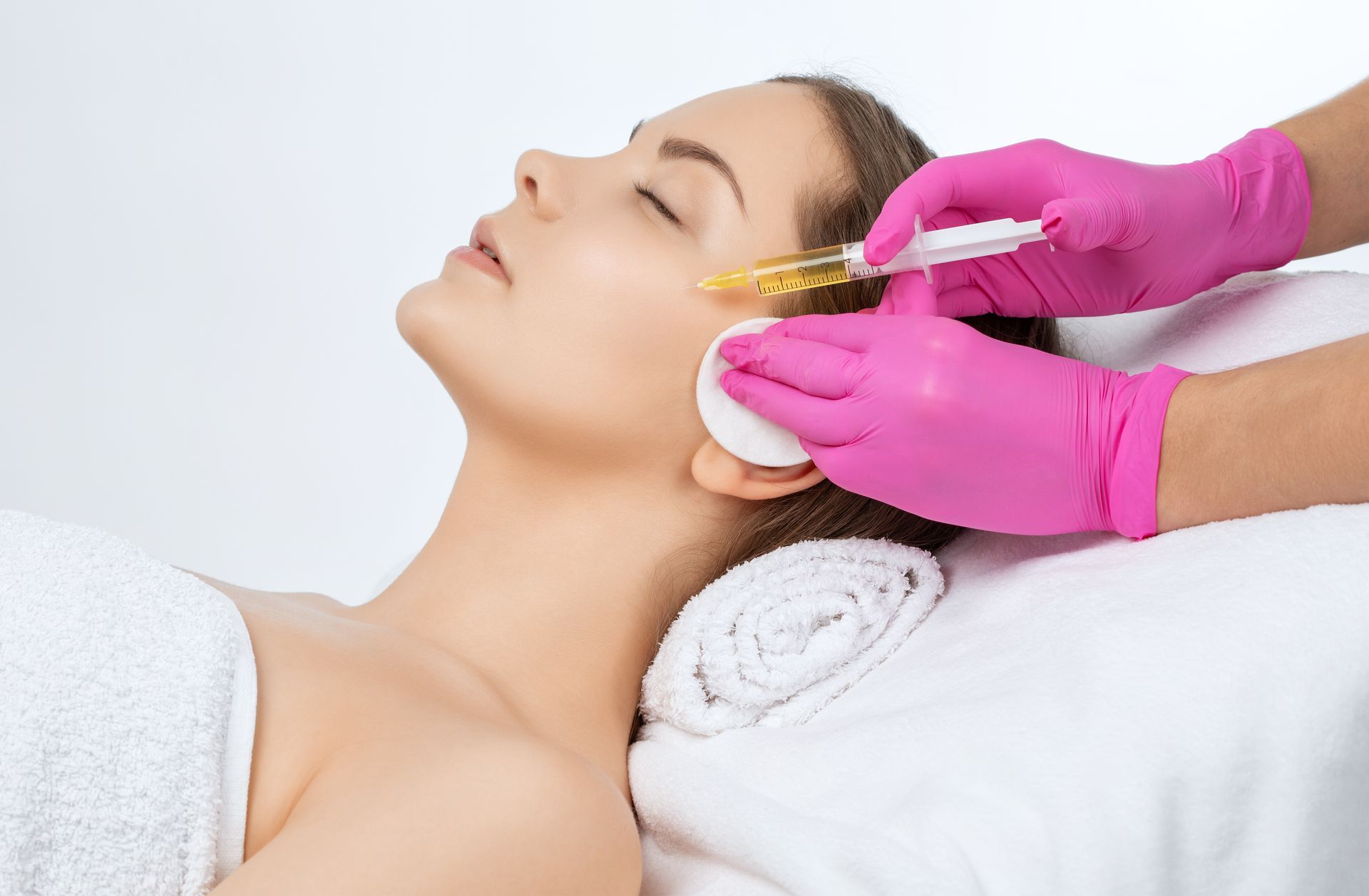 A woman is getting an injection in her face in a beauty salon.