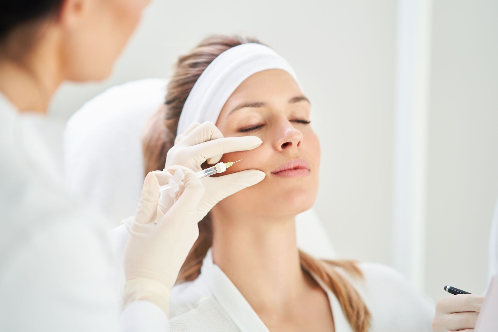 A woman is getting a botox injection in her face.