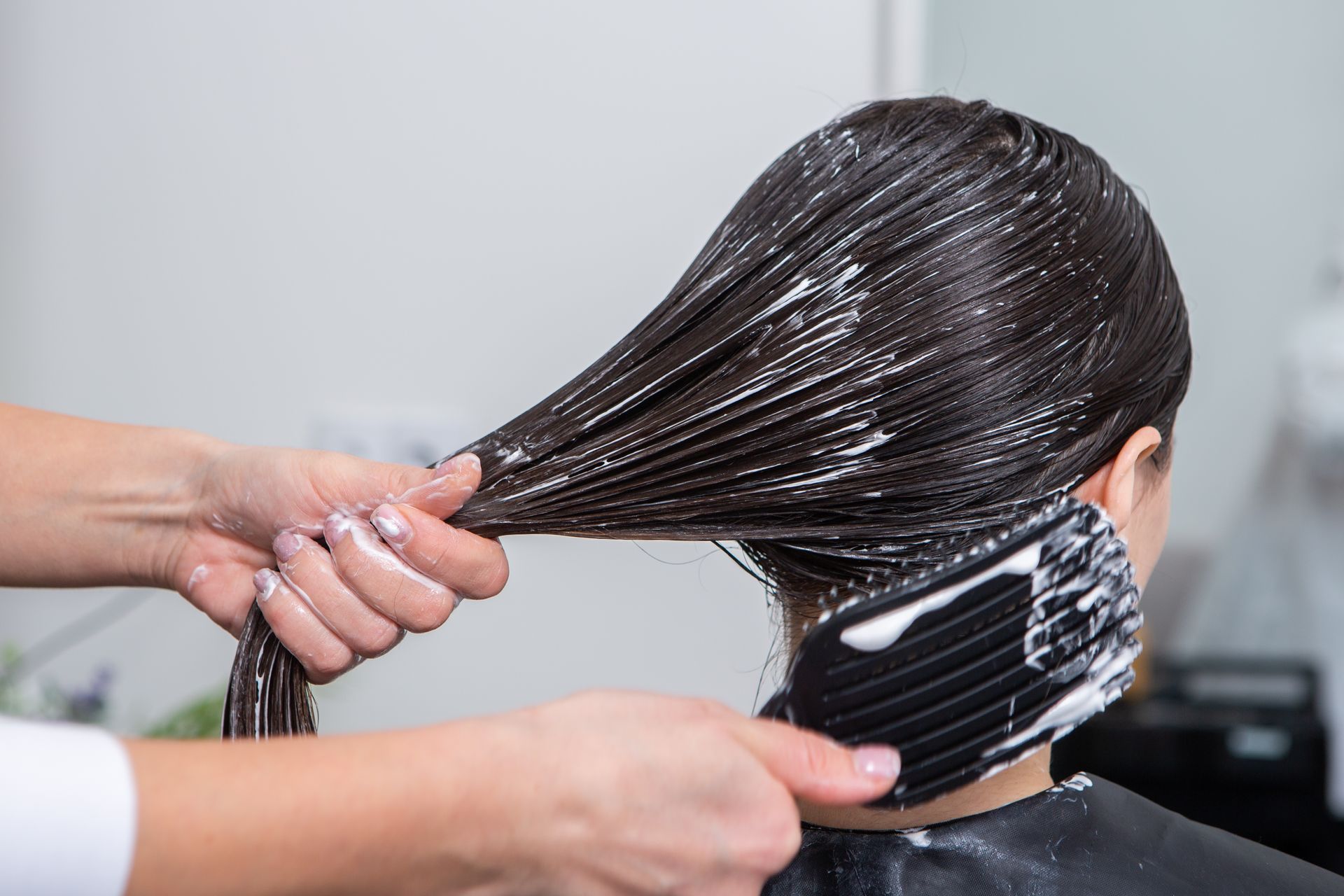 A woman is getting her hair dyed in a salon.