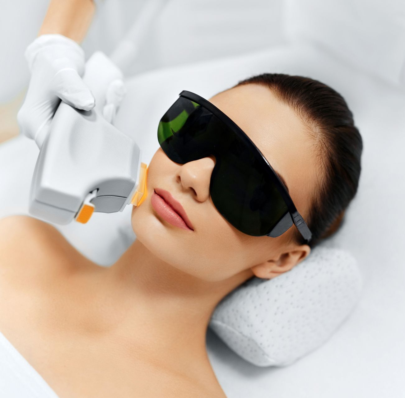 A woman is getting a laser treatment on her face.