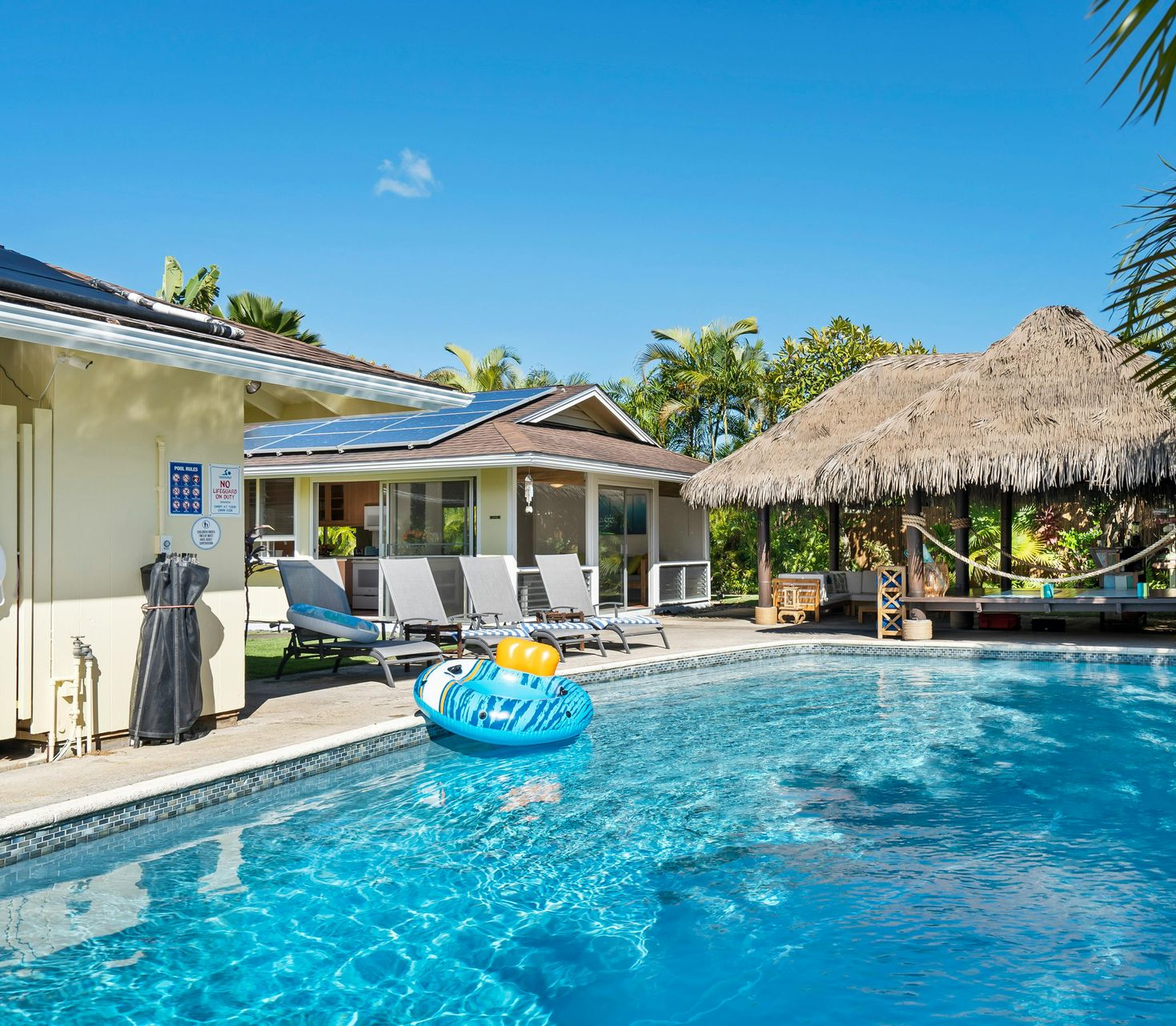 An aerial view of a house with solar panels on the roof.