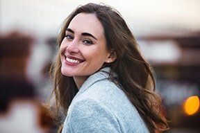 Beautiful Woman with Charming Smile Walking Outdoor — Family Dentistry in Hunstville, AL Beautiful Woman with Charming Smile Walking Outdoor — Family Dentistry in Hunstville, AL