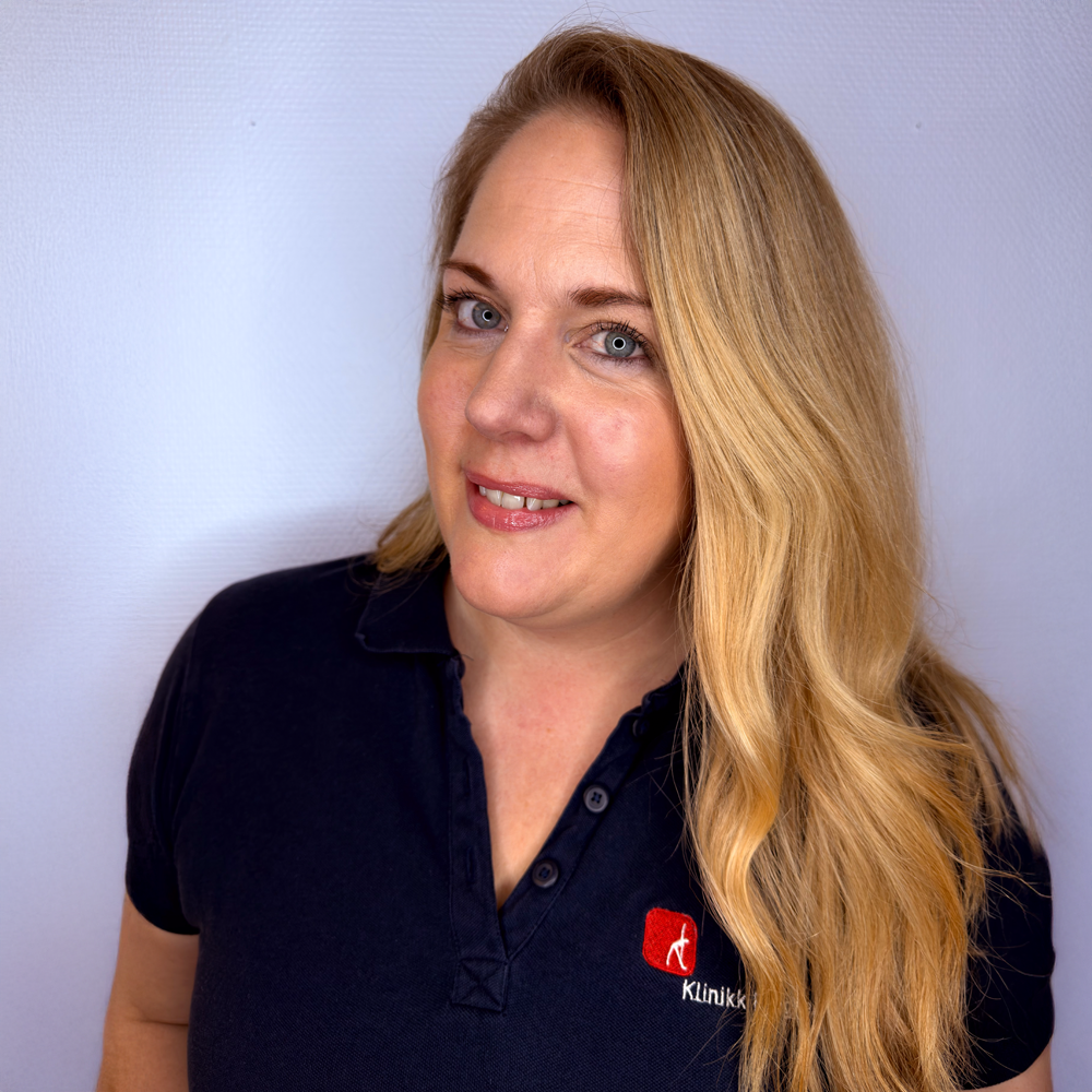 En person i svart sports og shorts får ryggen undersøkt av noen i blå skjorte.