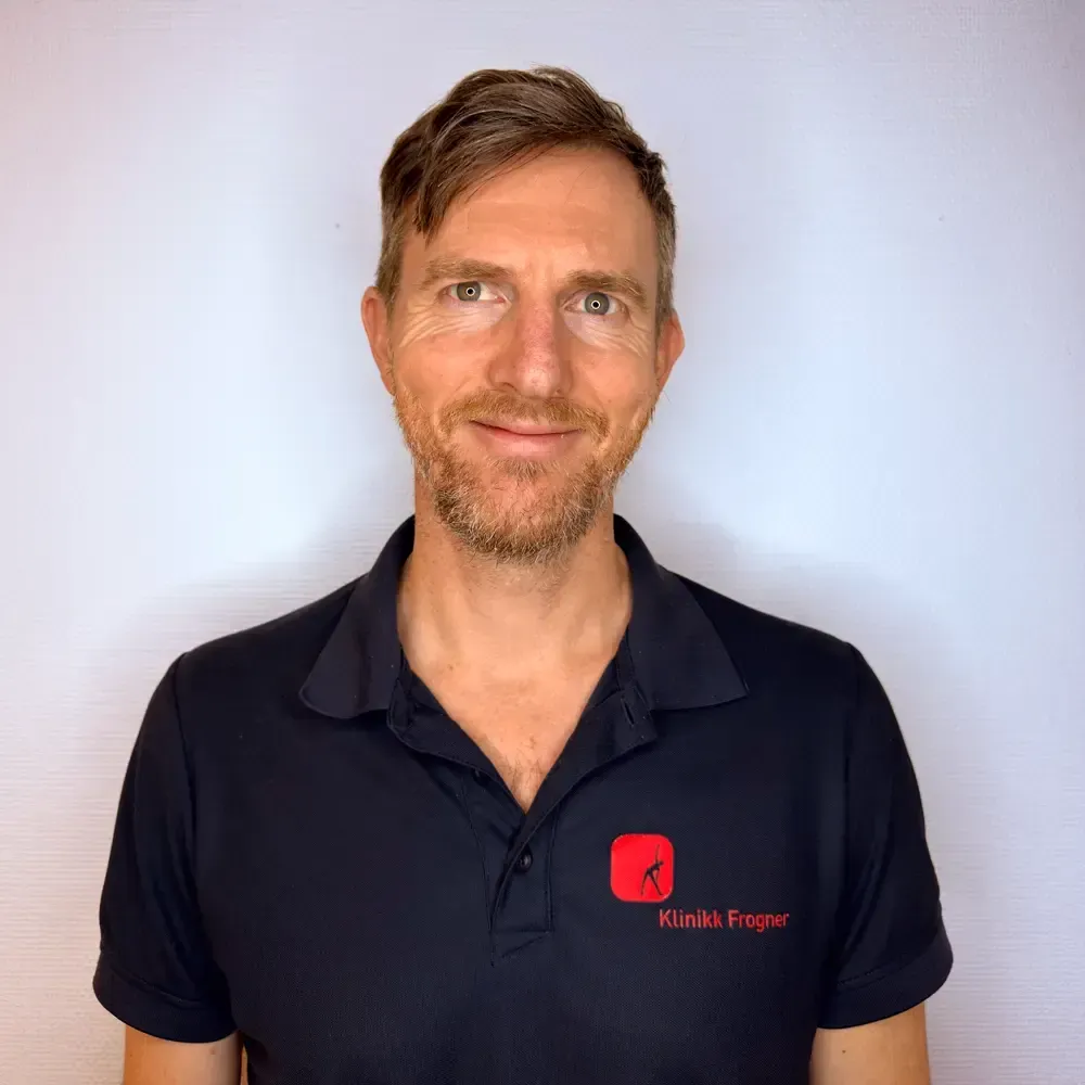 En person i svart sports og shorts får ryggen undersøkt av noen i blå skjorte.