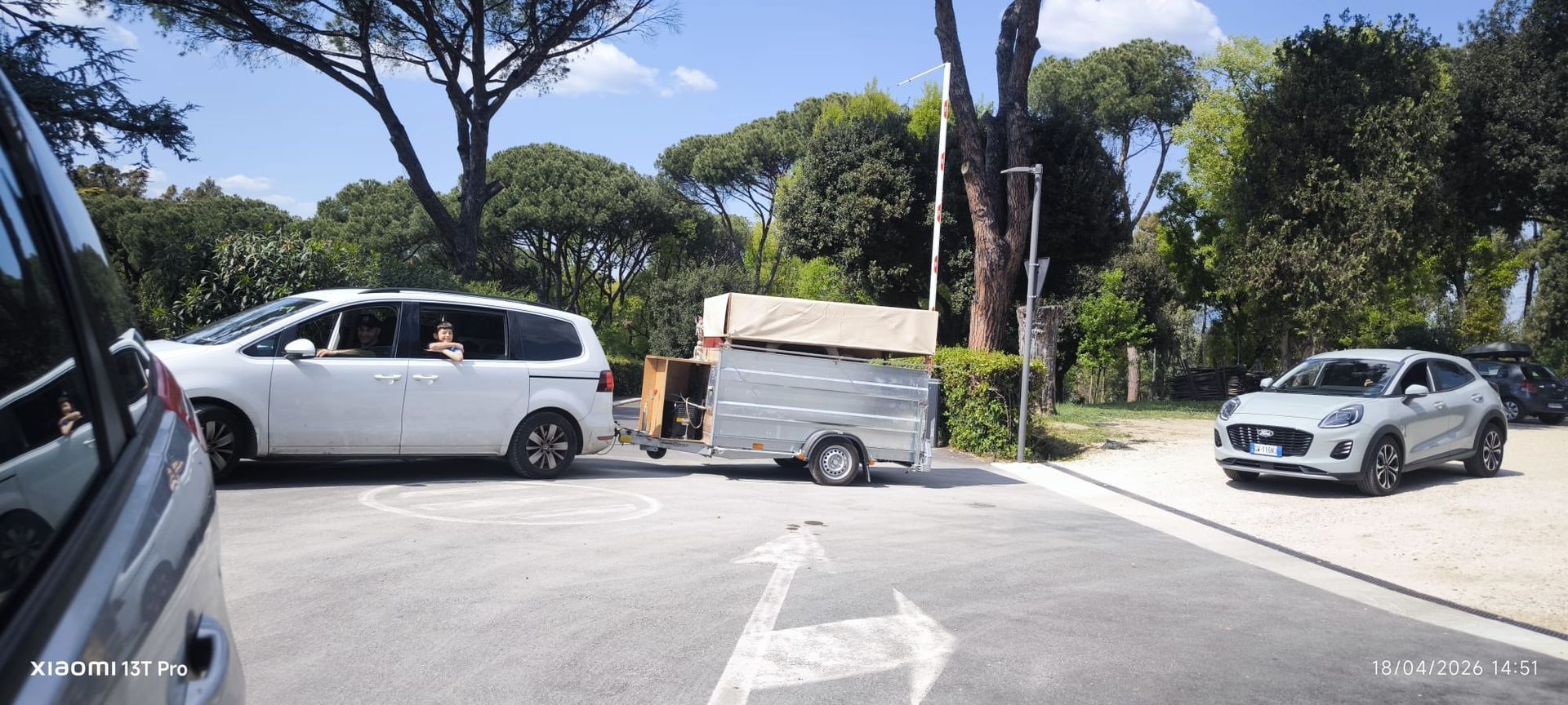 Le auto erano ferme a un incrocio soleggiato con alberi e un furgone davanti.