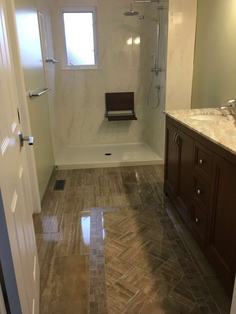 Bathroom with brown tile floor, white shower, and dark wood vanity.