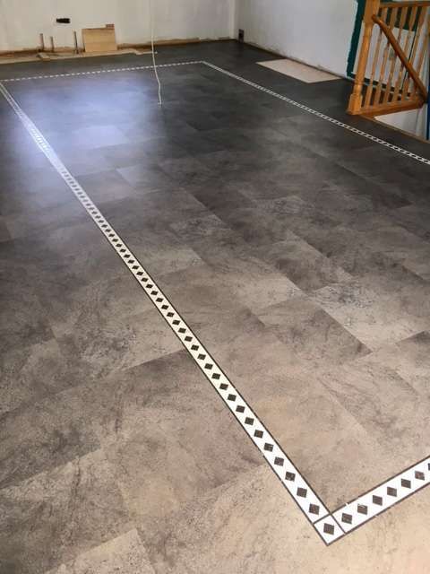 Dark gray floor with a white, patterned border, possibly for sports or games.