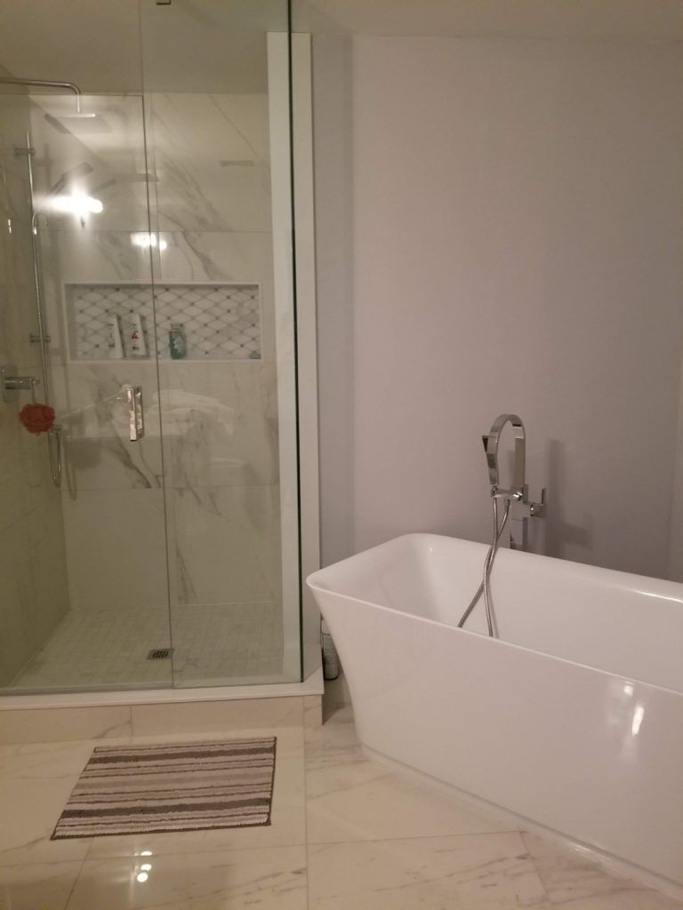 Modern bathroom with a white freestanding tub and a glass shower.