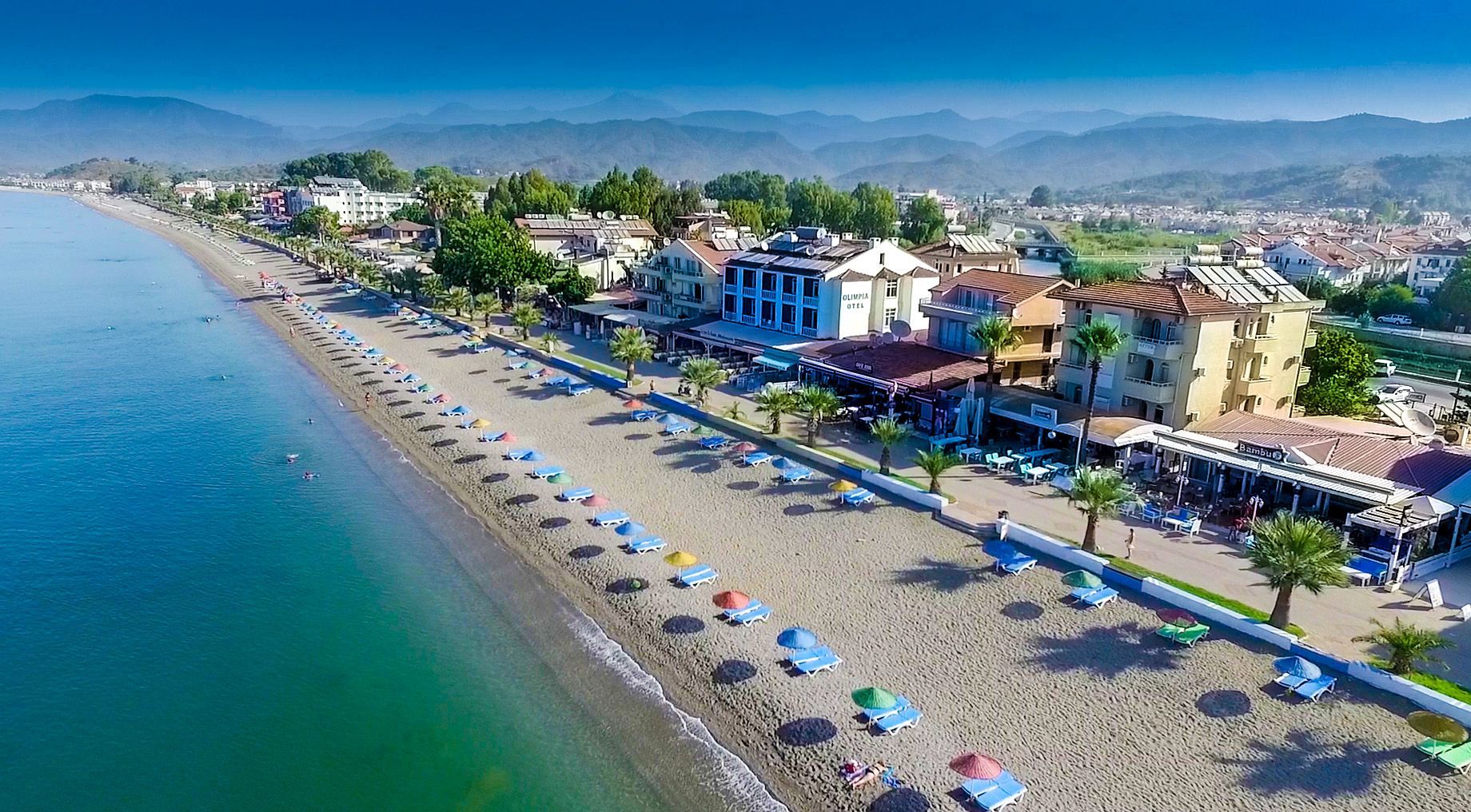 An aerial view of a beach with lots of chairs and umbrellas.