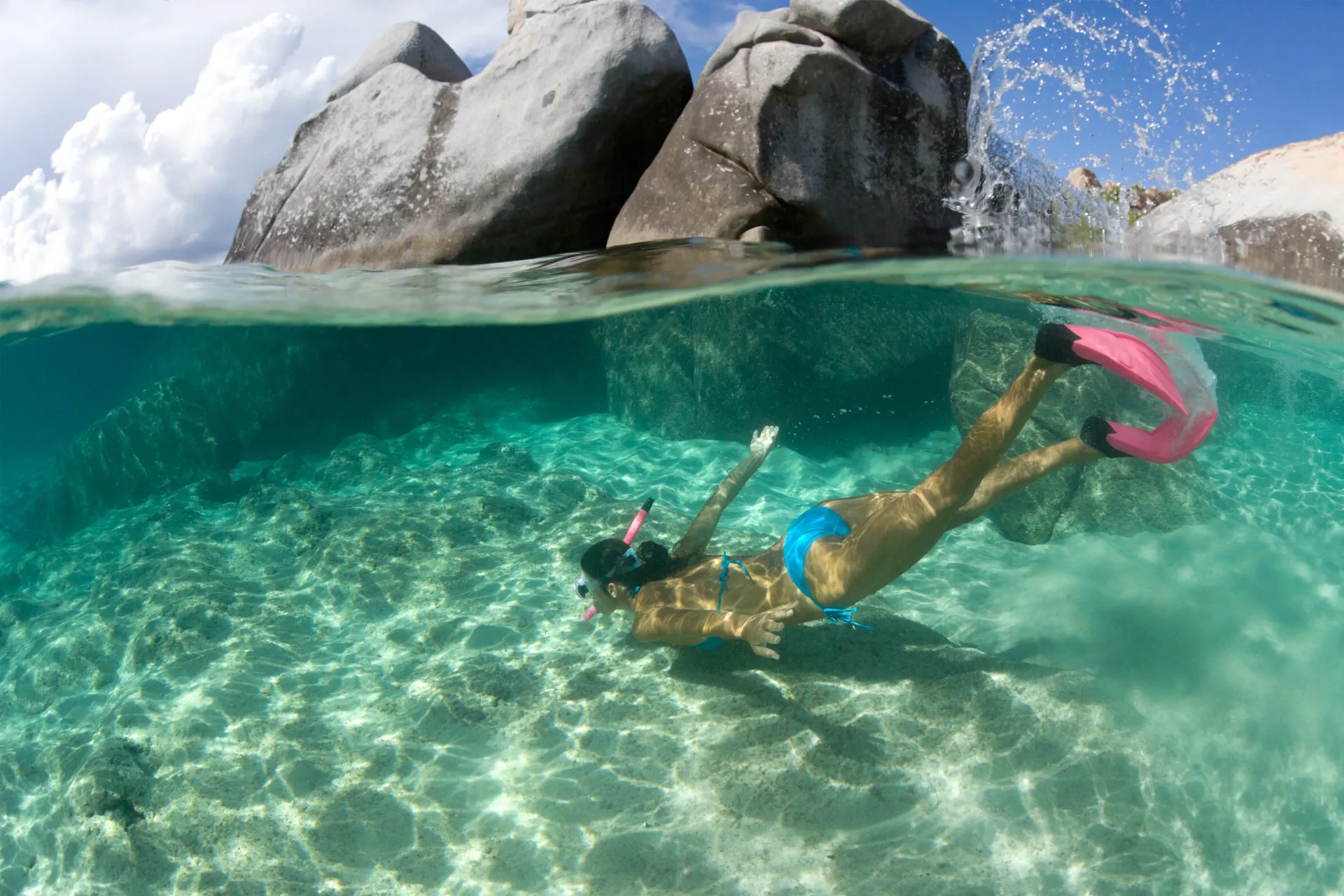 A woman in a bikini is swimming in the ocean.