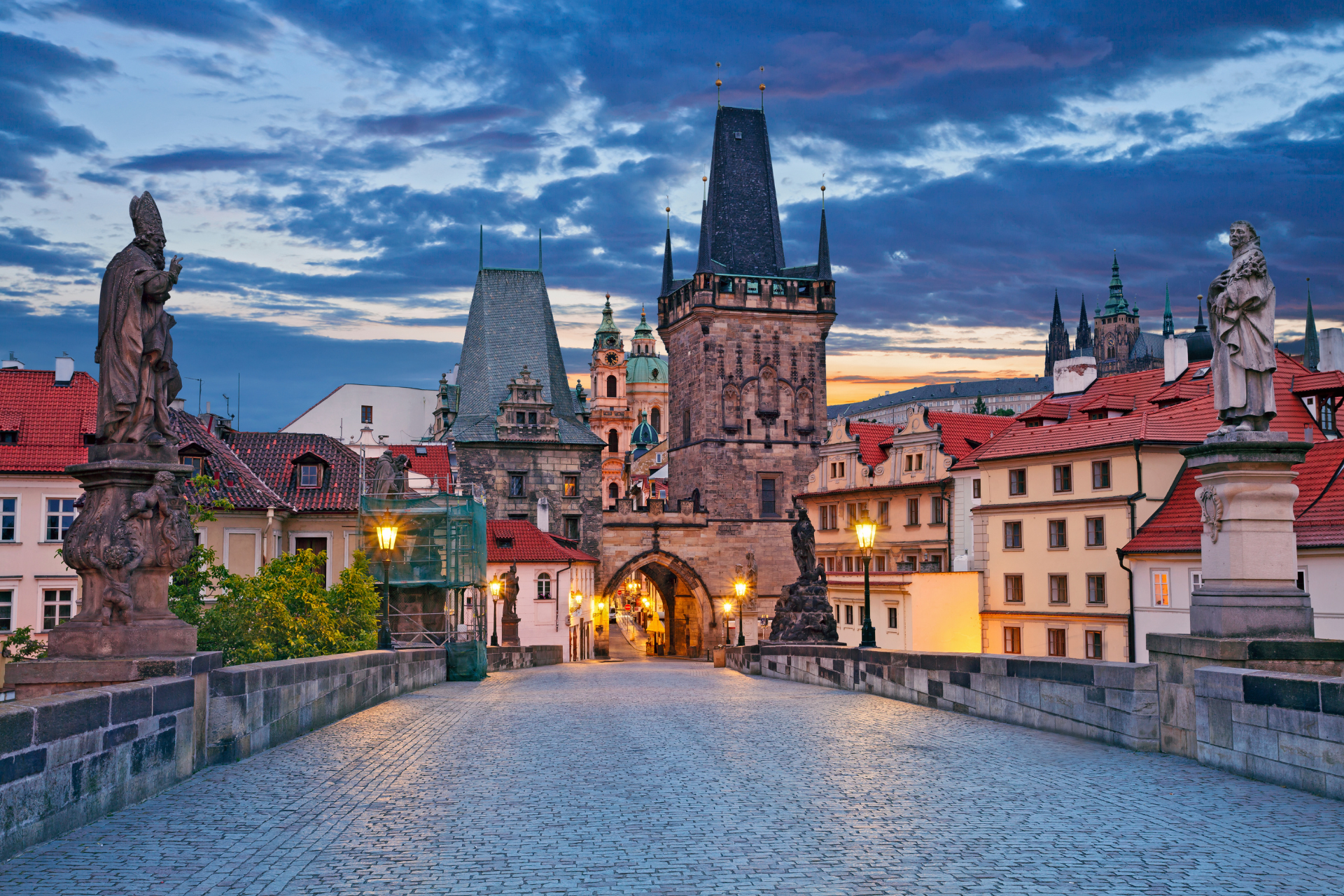 A bridge over a river in a city with a tower in the background.