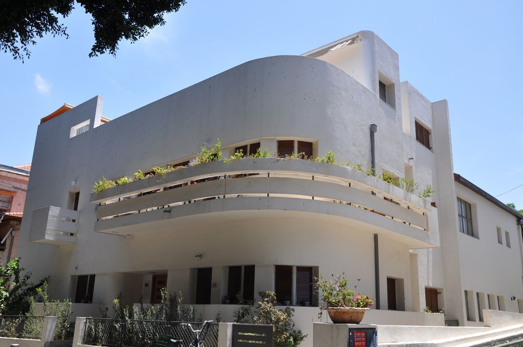 A large white building with a balcony on the side