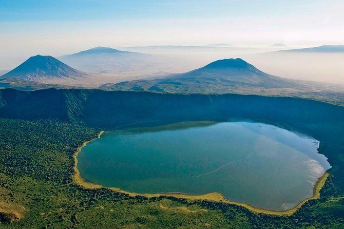 An aerial view of a lake surrounded by mountains and trees.