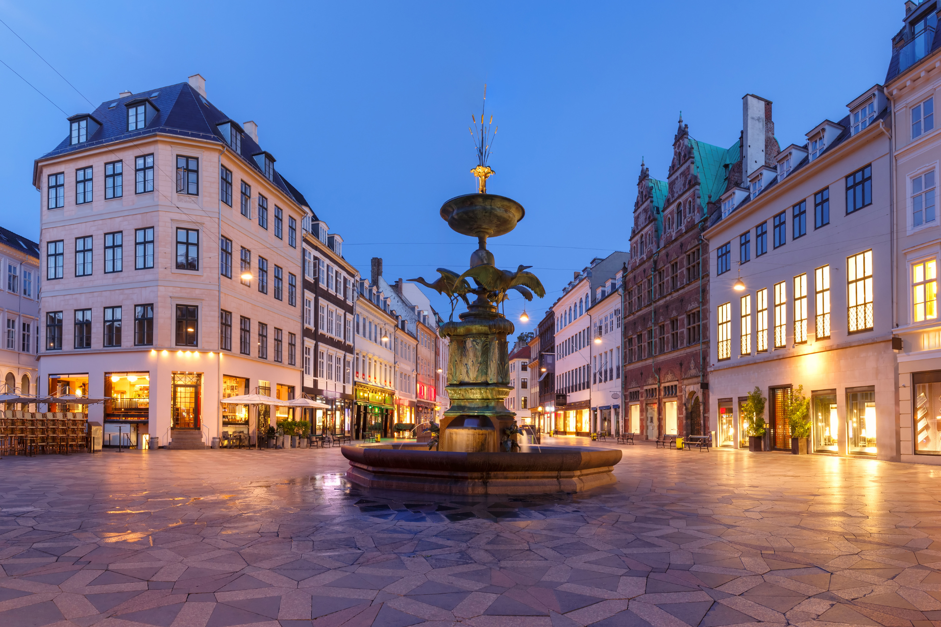 A fountain in the middle of a city with buildings in the background