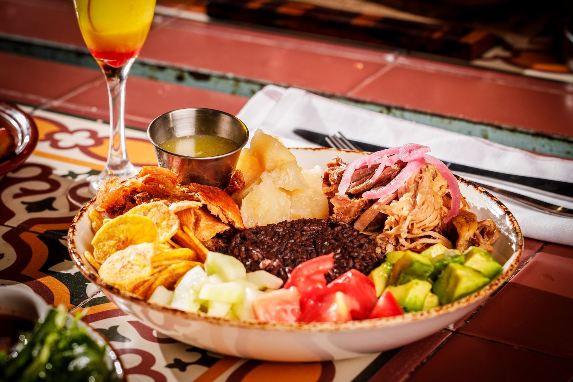 A plate of food with a glass of wine on a table.