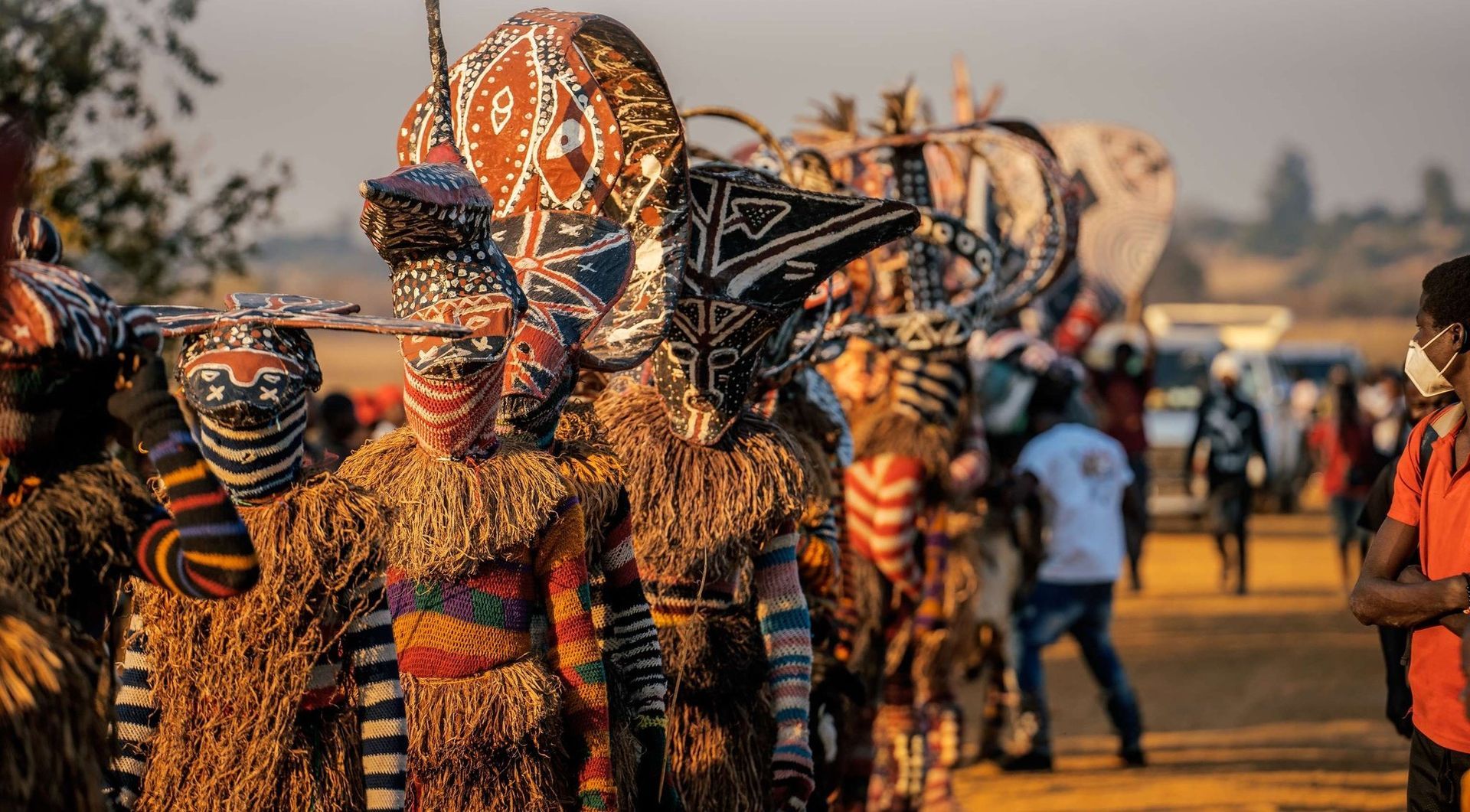 A group of people dressed in traditional costumes are walking down a street.