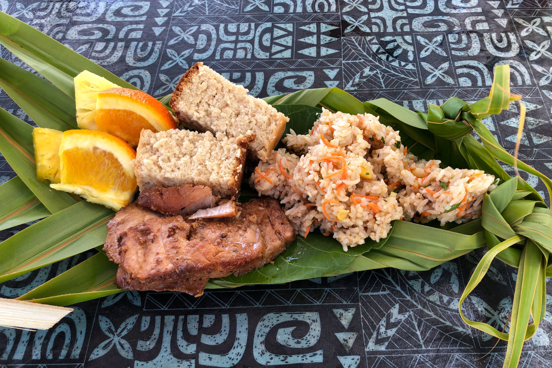 A close up of a plate of food on a leaf on a table.