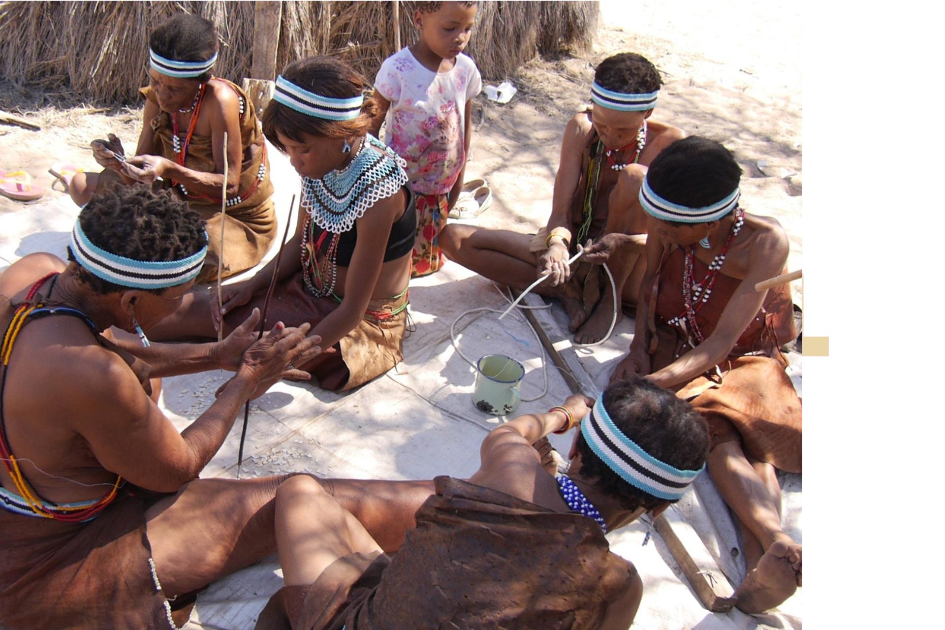 A group of people wearing headbands are sitting on the ground.