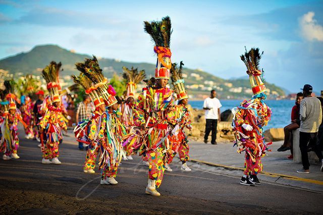 A group of people in colorful costumes are marching down a street.