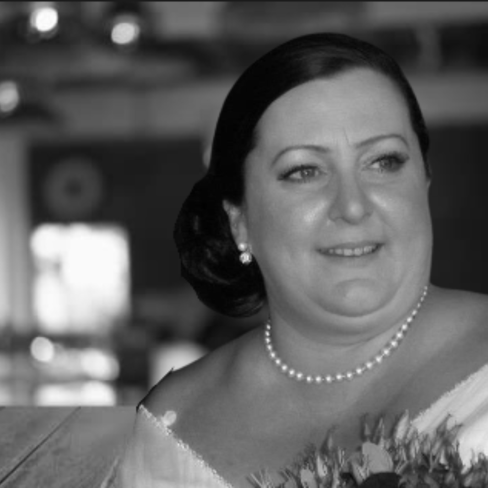 A black and white photo of a woman wearing a pearl necklace