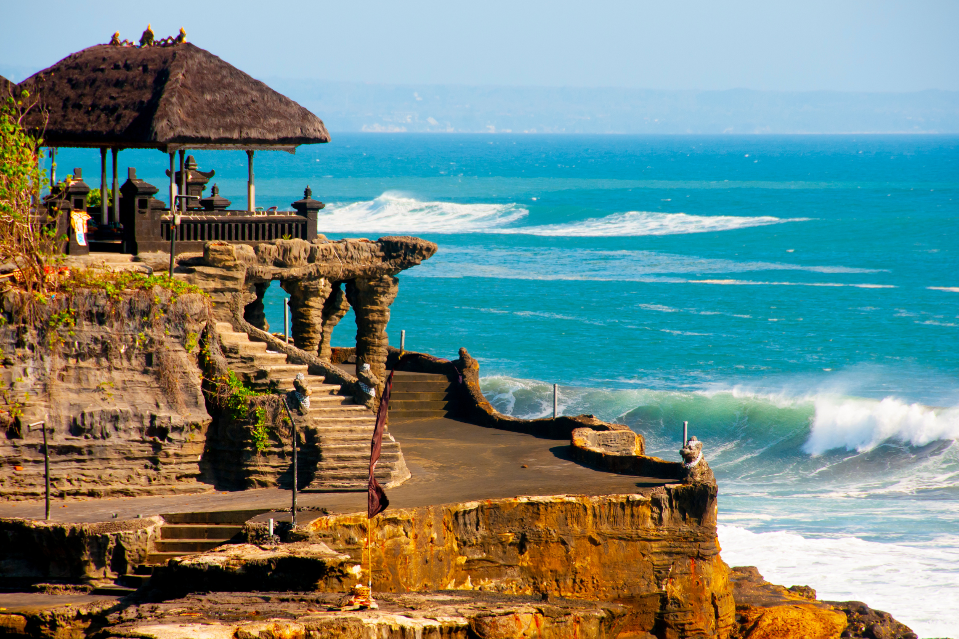 A cliff overlooking the ocean with a hut on top of it