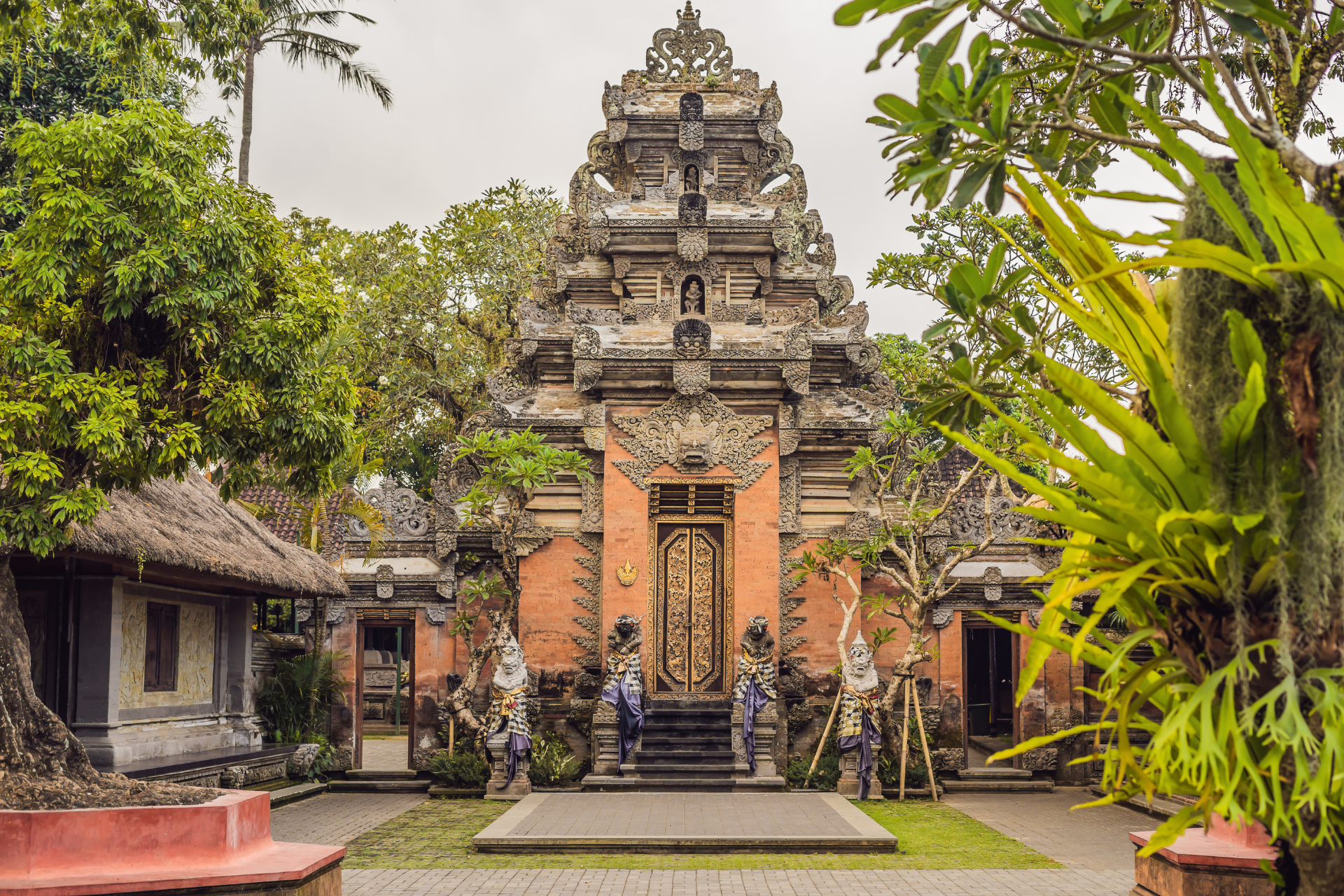 There is a temple in the middle of a lush green forest.