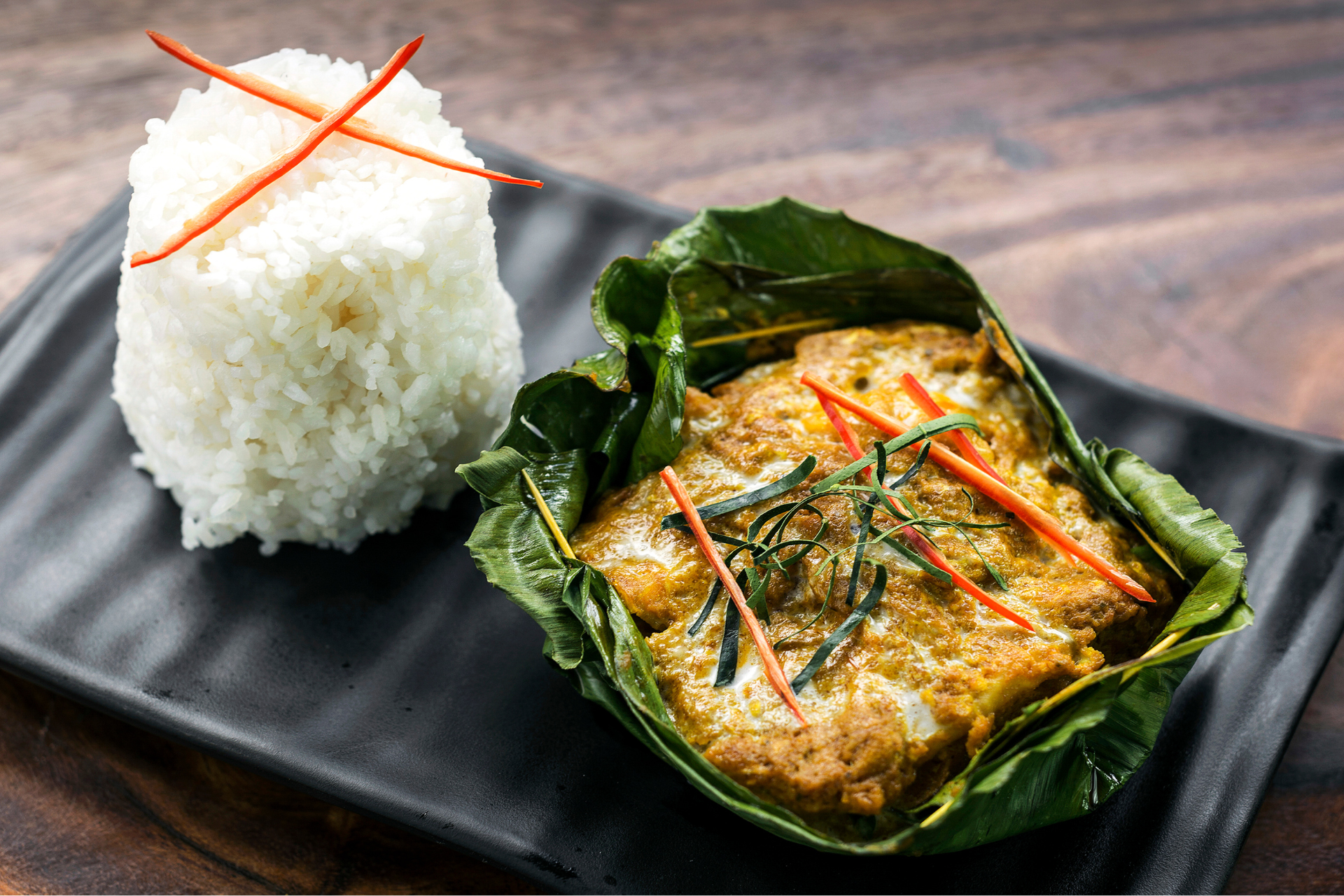 A close up of a plate of food with rice on a table.