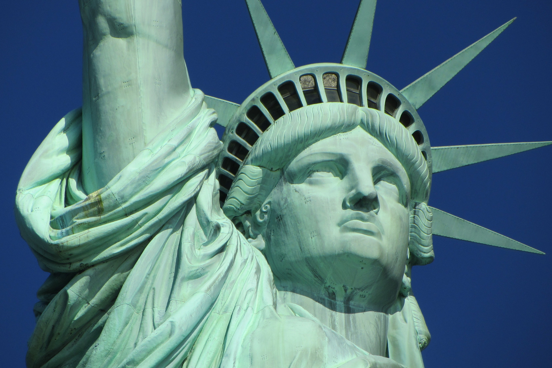 A close up of the statue of liberty against a blue sky