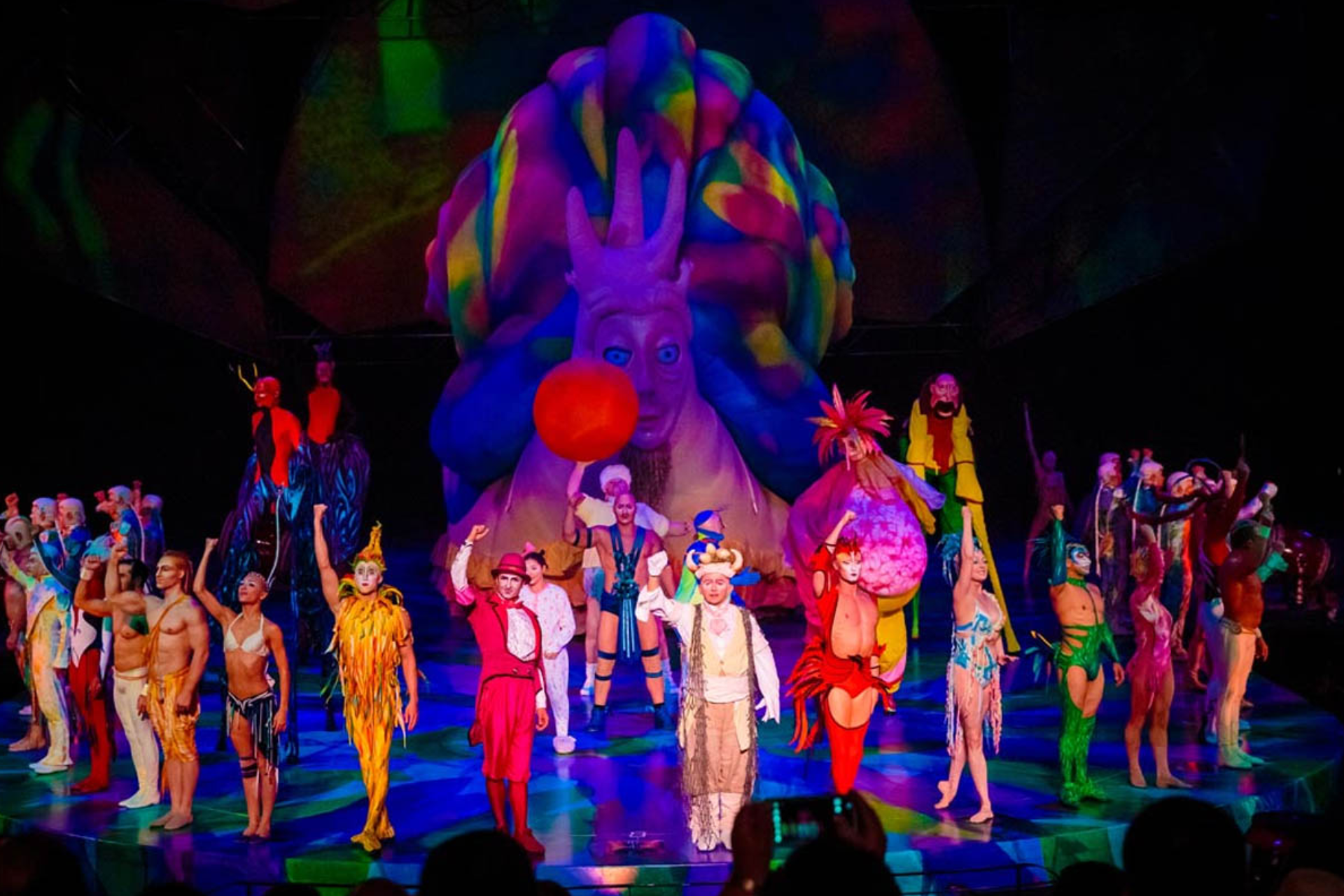 A group of people are standing on a stage in front of a large balloon.
