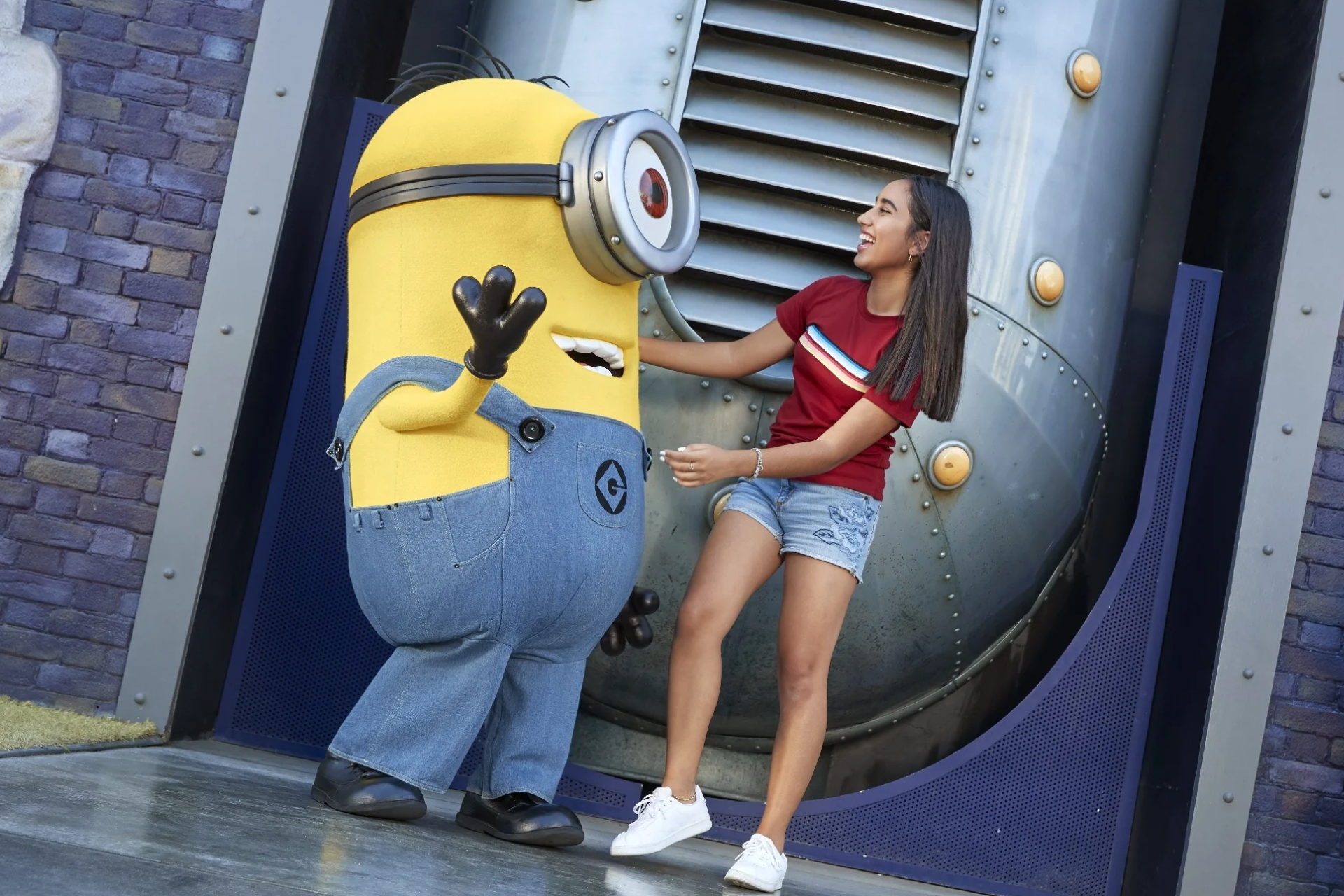 A woman is standing next to a minion mascot.
